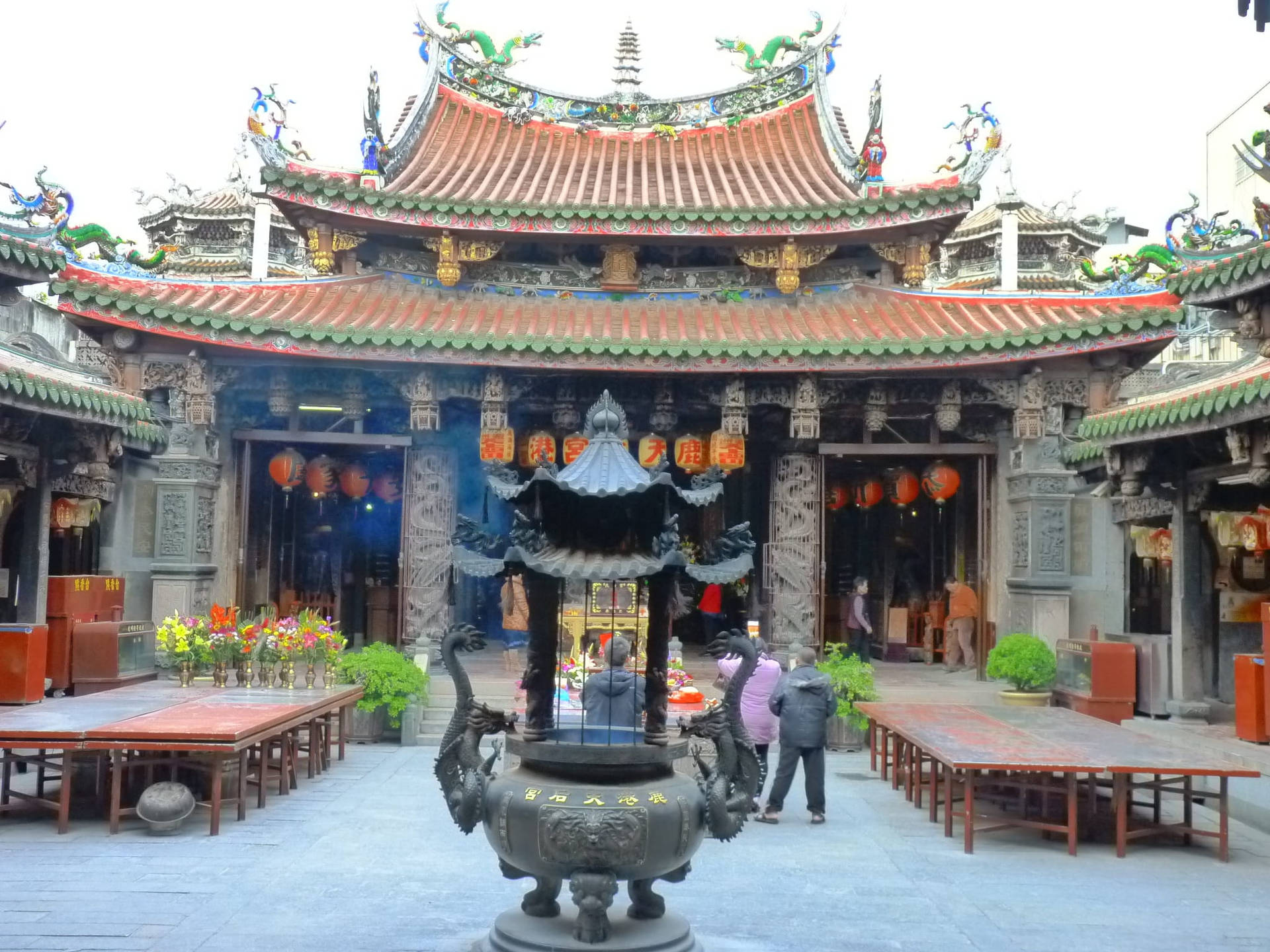  壁紙 — 一個宏偉的傳統中式寺廟庭院，擁有華麗的瓦頂、龍雕塑、紅燈籠和中央一個大香爐。