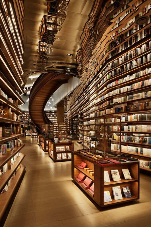 Library 桌布 壁紙 — 一個宏偉的圖書館，高聳的木製書架向上彎曲，沿著螺旋樓梯被溫暖的燈光照亮。