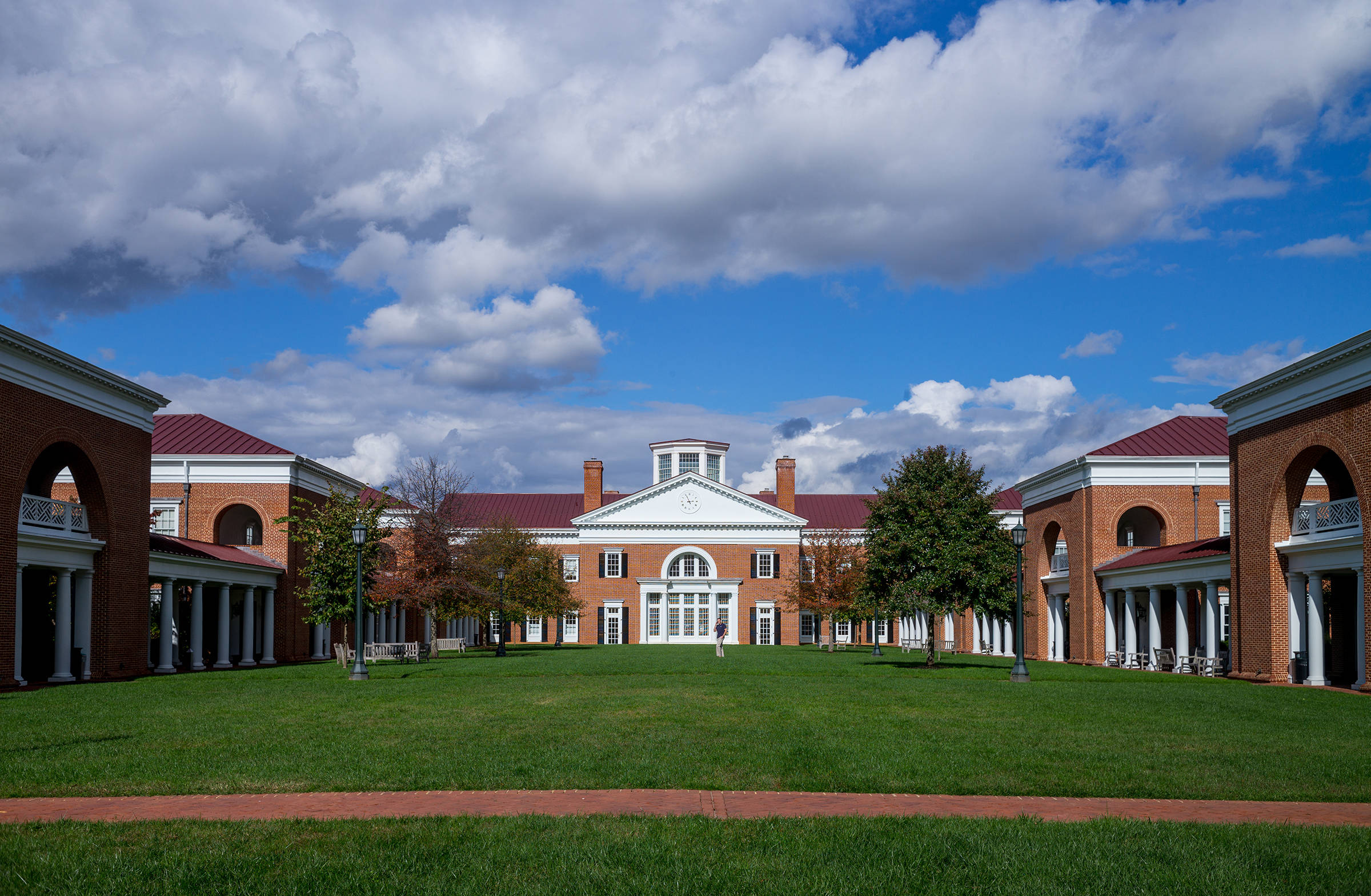Virginia 桌布 壁紙 — 一個宏偉的磚造大學庭院，擁有白色柱子和紅色屋頂，在明亮的藍天下有蓬鬆的雲朵。