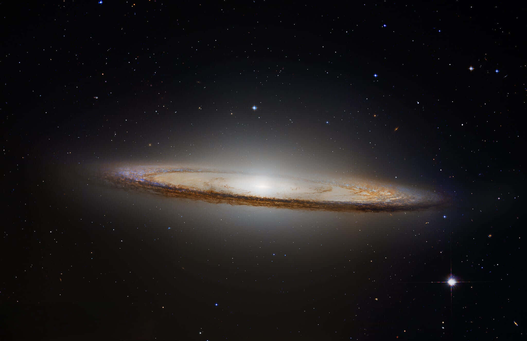 Sombrero Galaxy 桌布 壁紙 — 一個宏偉的螺旋星系在宇宙之夜中閃耀著金色塵埃帶，襯托著星場。