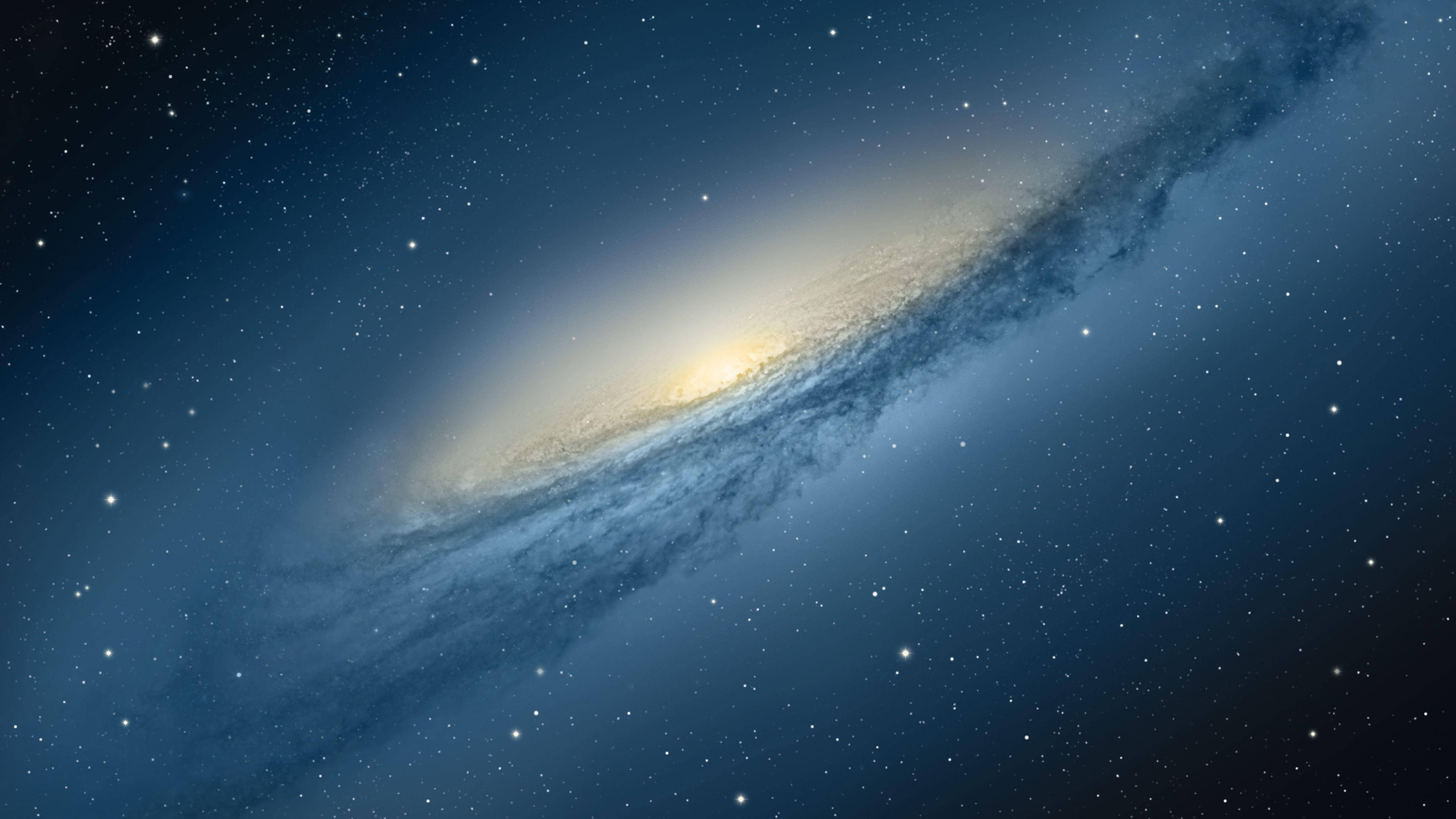 mac 4K 桌布 壁紙 — 一個宏偉的螺旋星系在星空中閃耀著金色核心和旋轉的藍色旋臂。