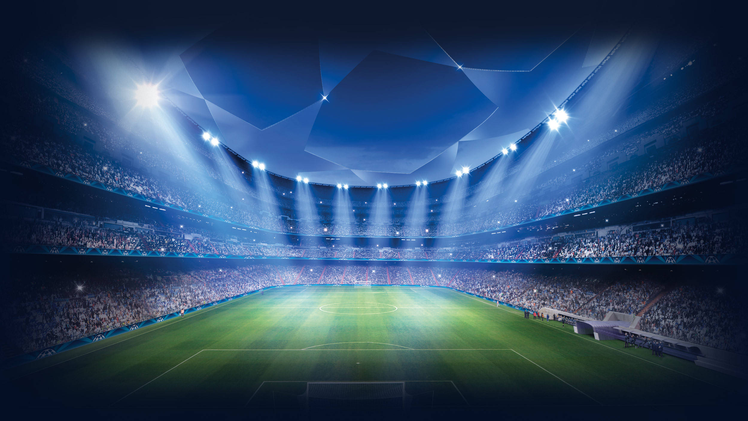 Uefa 桌布 壁紙 — 一個宏偉的足球場沐浴在明亮的藍色聚光燈下，照亮了充滿活力的綠色球場，周圍擠滿了歡呼的人群。