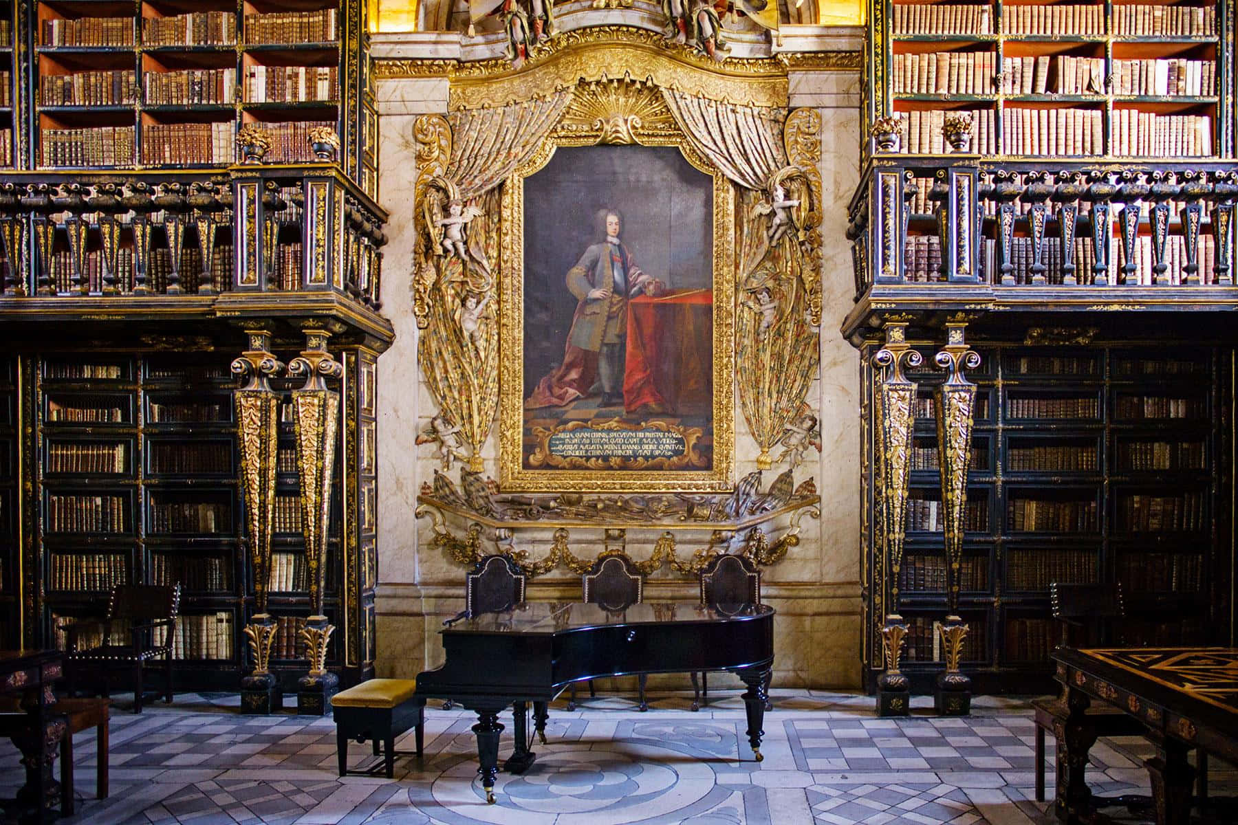The Hogwarts Library 桌布 壁紙 — 一個宏偉華麗的圖書館，擁有高聳的書架、金色裝飾，以及一個大型肖像畫置於黑色三角鋼琴上方中央。