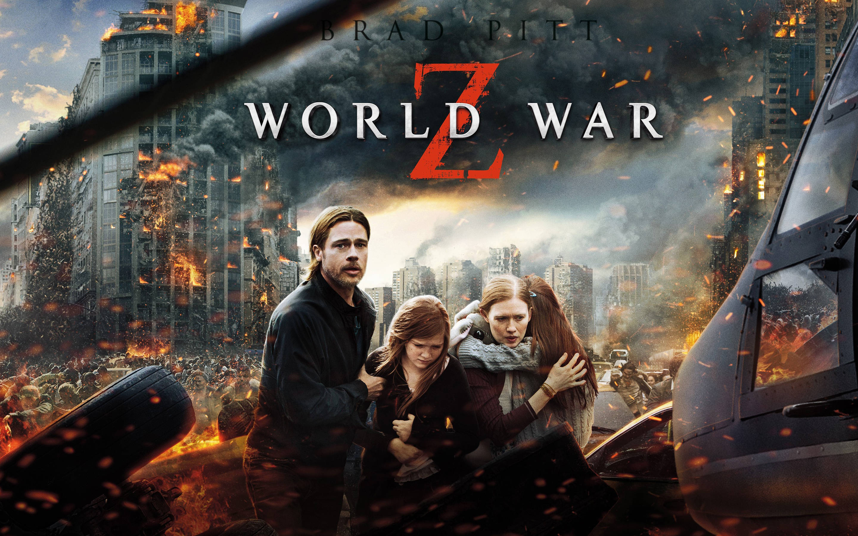world war z 4K 桌布 壁紙 — 一個家庭在一個被殭屍淹沒的燃燒城市中緊緊依偎，這是一張戲劇性的末日電影海報。