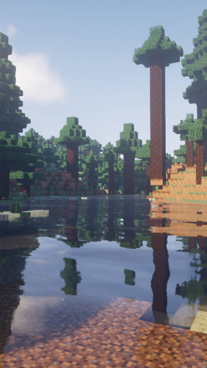 電玩遊戲 桌布 壁紙 — 一個寧靜的Minecraft森林，有方塊樹木在晴朗天空下平靜的水面倒影。