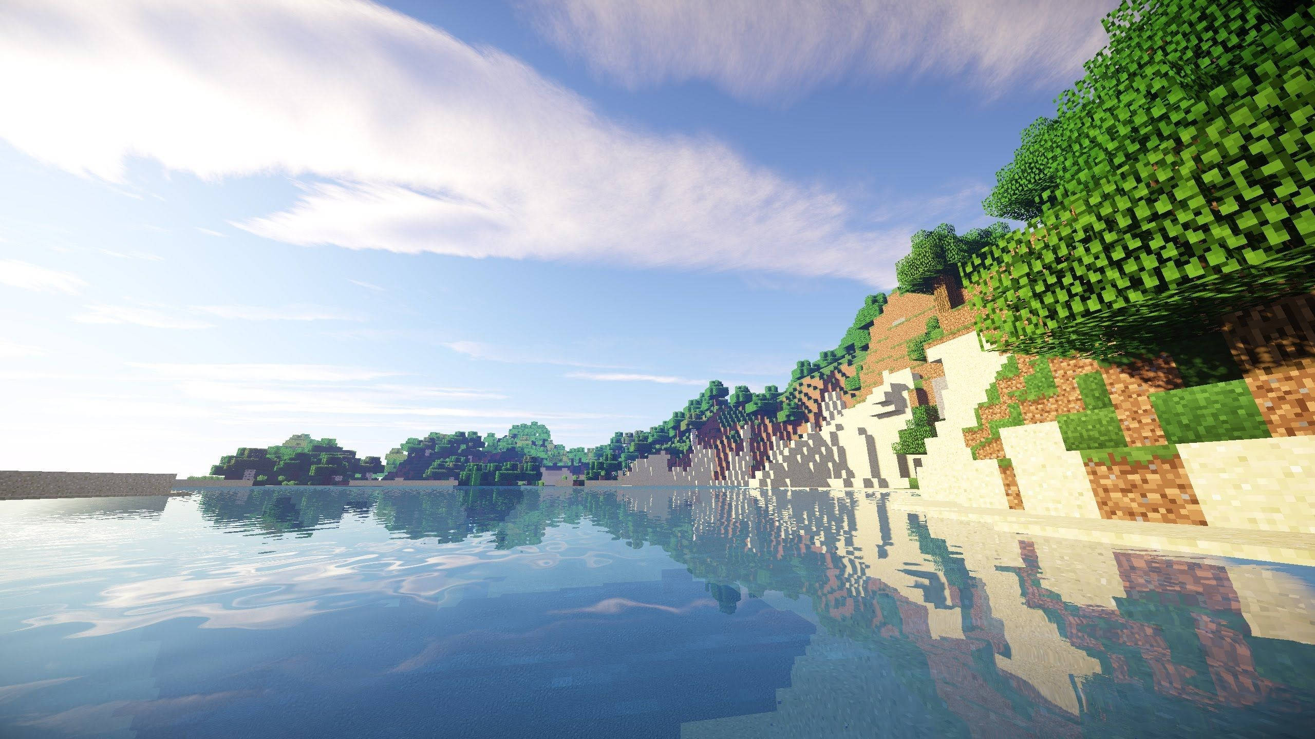 最佳我的世界 桌布 壁紙 — 一個寧靜的Minecraft風景，像素化的樹木和懸崖倒映在平靜的藍色水面上，天空晴朗。