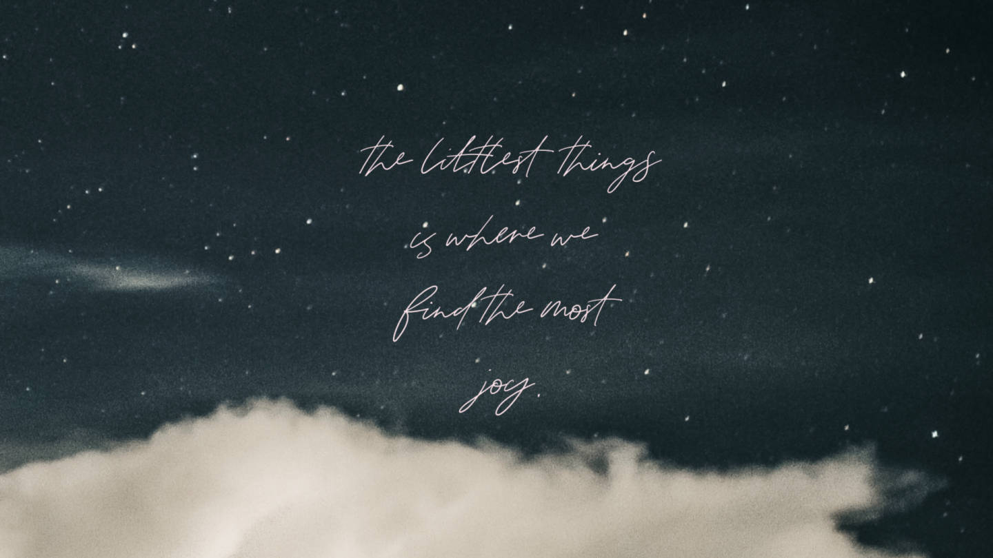 語錄 桌布 壁紙 — 一個寧靜的夜空，有星星和柔軟的雲朵，上面優雅地寫著草書文字：「最小的東西是我們找到最大快樂的地方」。