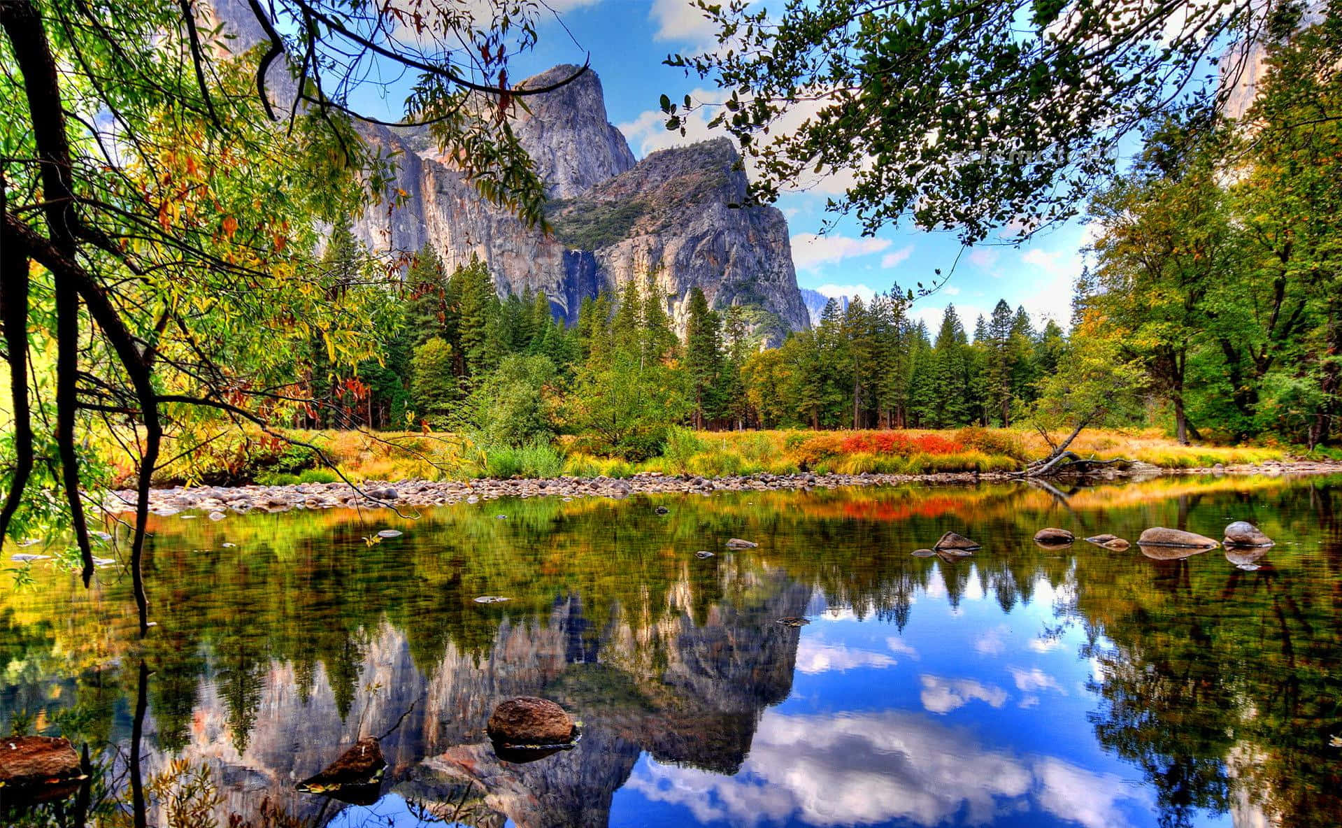 Beautiful Place 桌布 壁紙 — 一個寧靜的山谷，高聳的花崗岩懸崖倒映在平靜的河流中，四周環繞著秋天的樹葉。