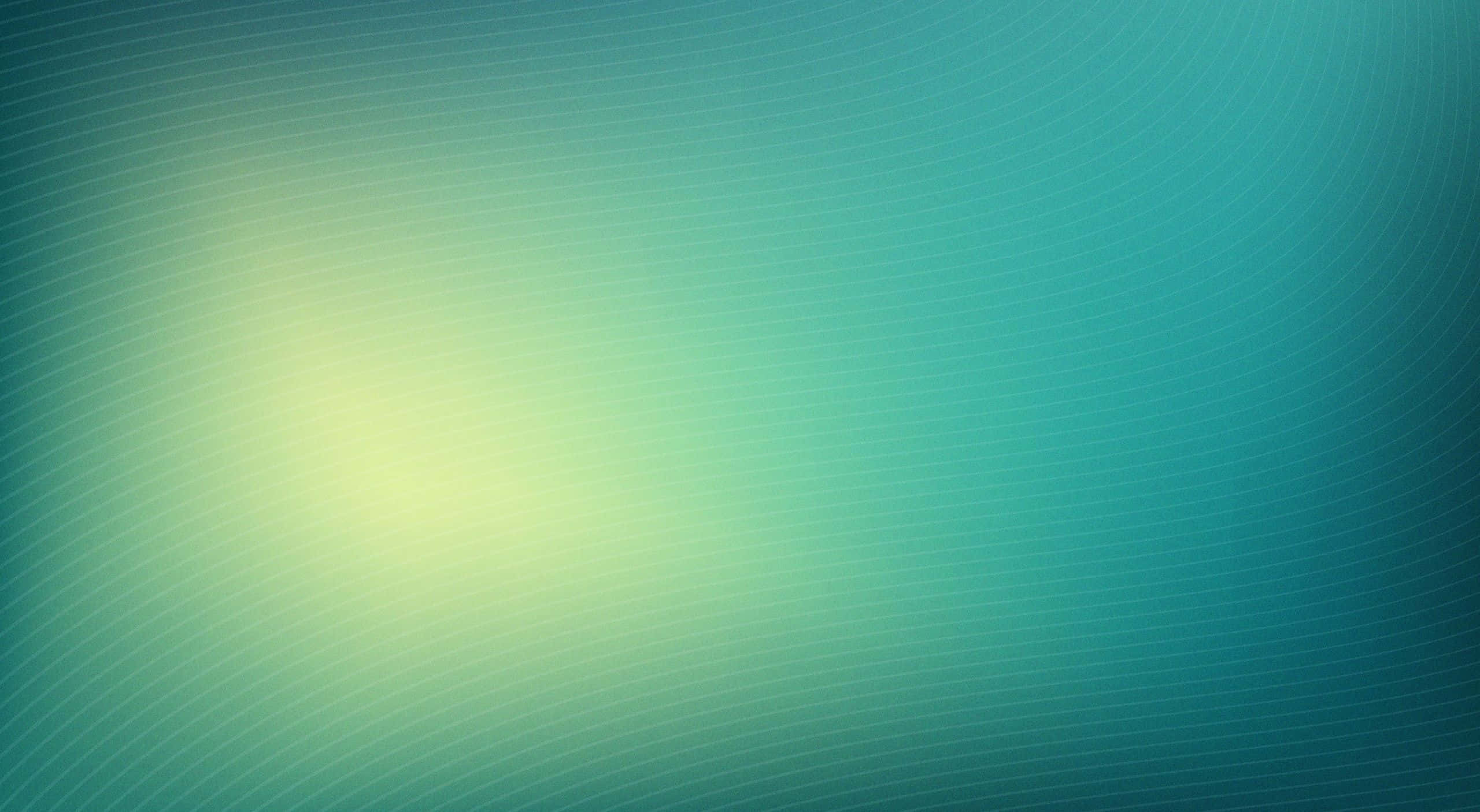 青色GIF 桌布 壁紙 — 一個寧靜的抽象漸變，帶有從柔和發光中心散發出的青綠色和黃色色調。