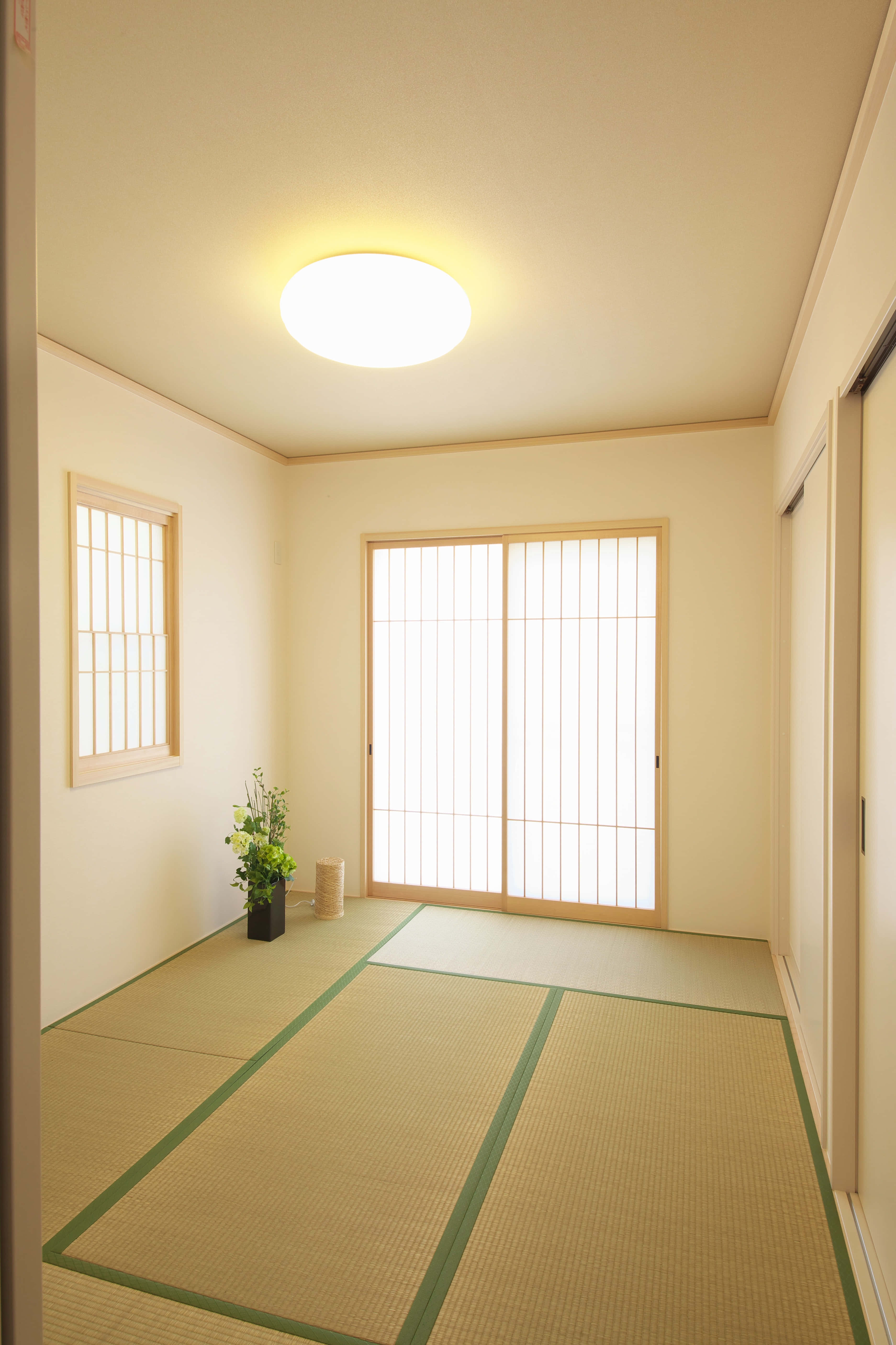 Empty Room 桌布 壁紙 — 一個寧靜的日式房間，配有綠色邊框的榻榻米、障子屏風和柔和溫暖的燈光，營造出簡約平和的氛圍。