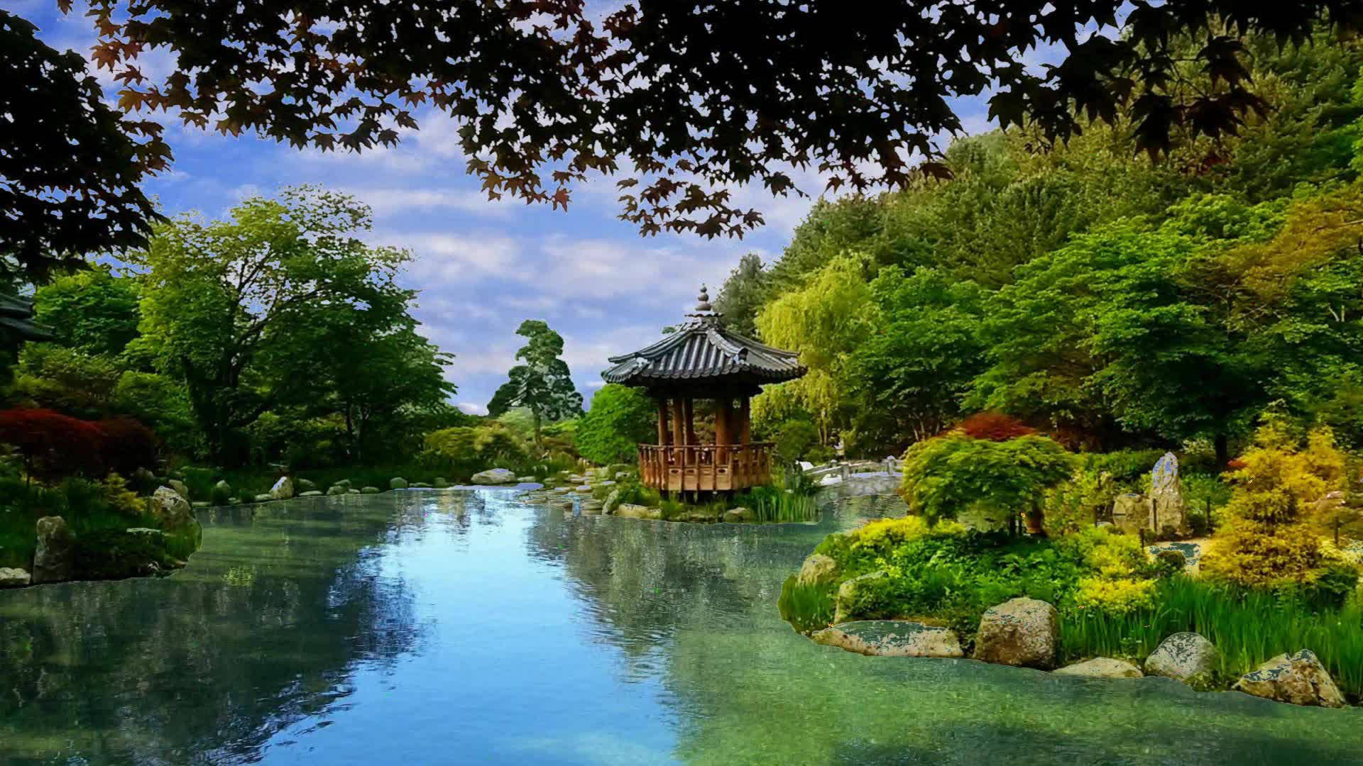 平靜 桌布 壁紙 — 一個寧靜的日本花園池塘倒映著傳統的木造亭子，周圍環繞著茂密的綠植和秋日樹木，上方是明亮的藍天。