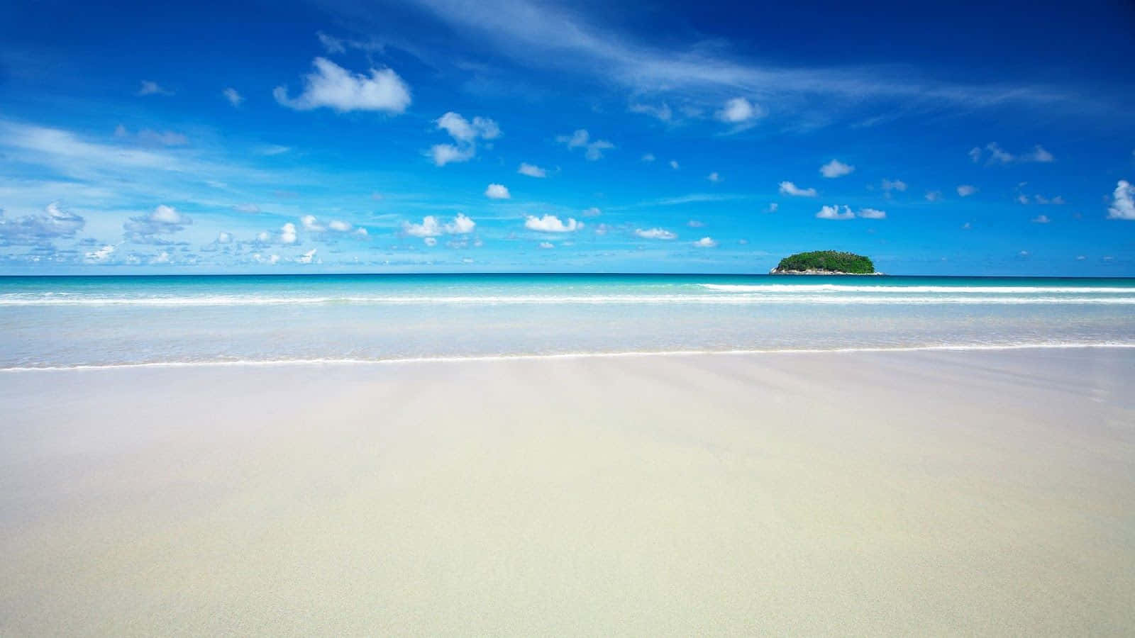Beach Scene 桌布 壁紙 — 一個寧靜的熱帶海灘，有粉狀白沙、溫柔的海浪、碧綠的海水，以及一個鬱鬱蔥蔥的綠色島嶼，在明亮的藍天下有散落的雲朵。