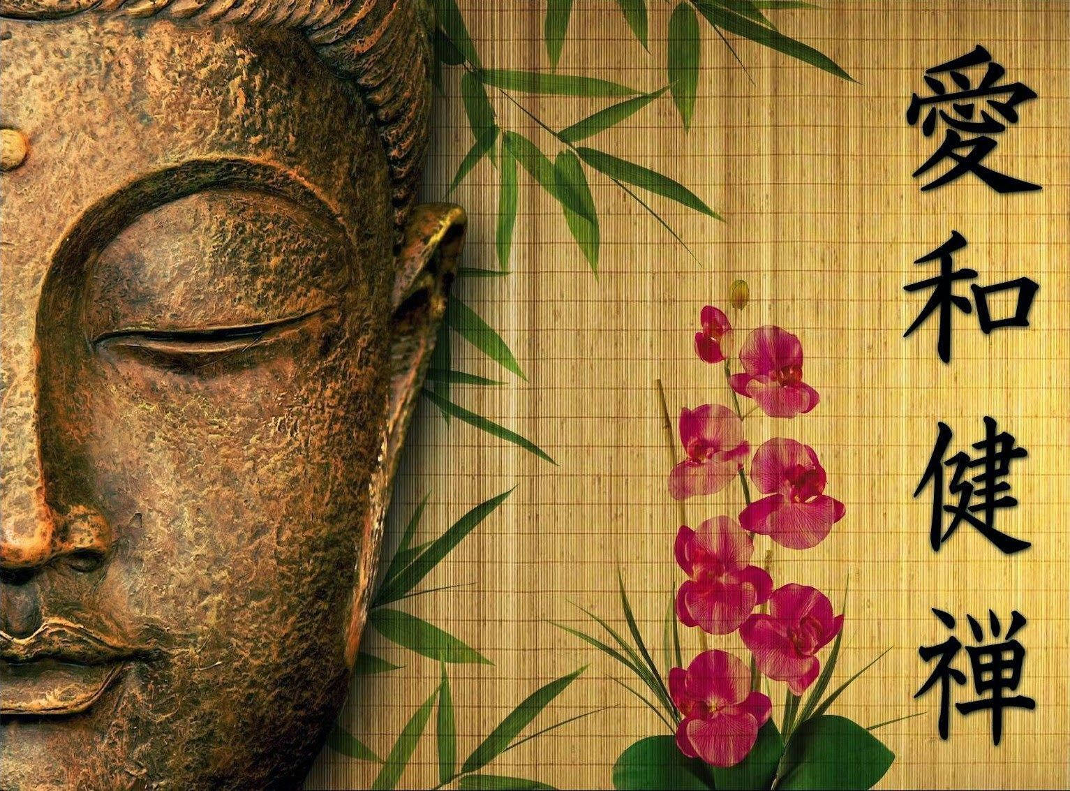 god laptop 桌布 壁紙 — 一個寧靜的青銅佛像頭部，旁邊有粉紅色蘭花和竹子，放在帶有中文字的竹蓆上。