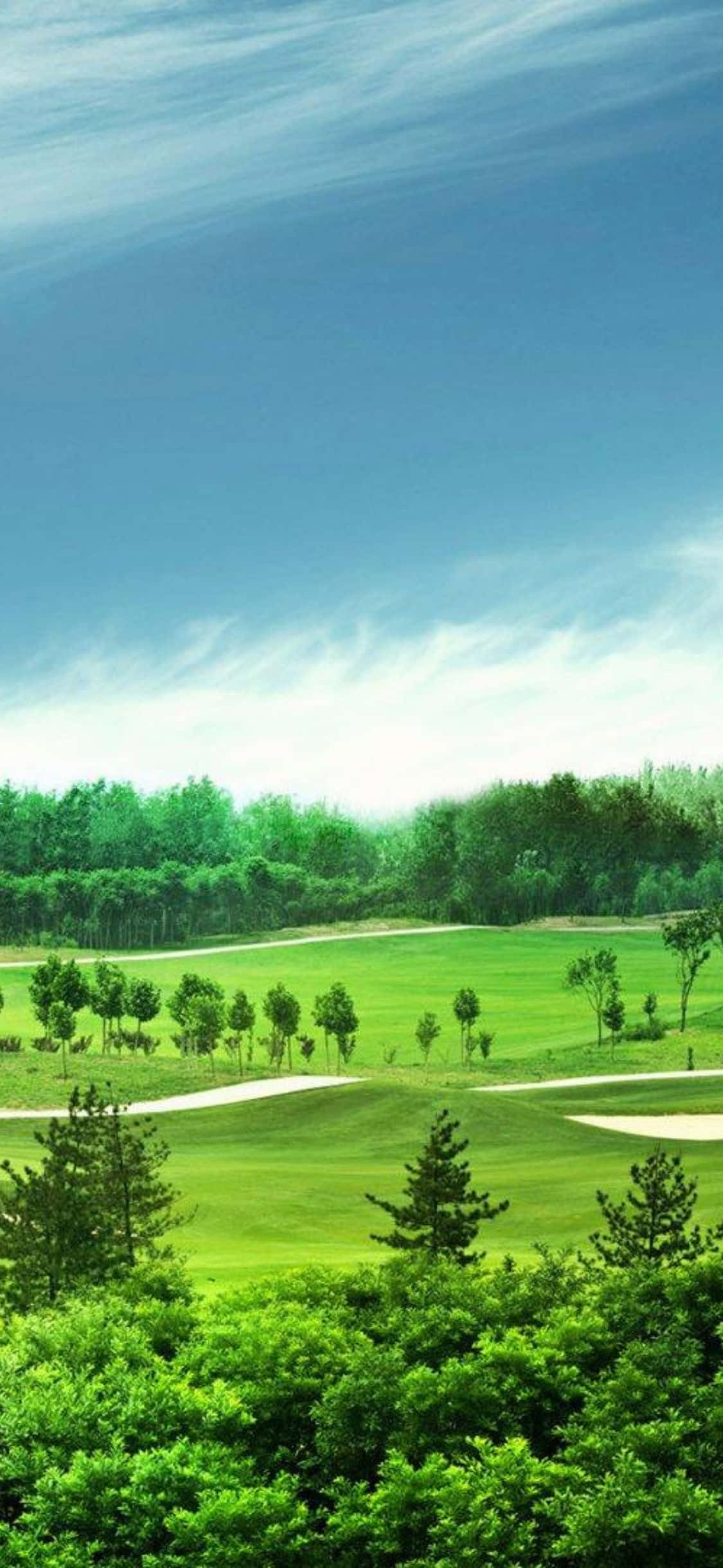 iPhone X Golf Course 桌布 壁紙 — 一個寧靜的高爾夫球場，擁有茂密的綠色球道和沙坑，在晴朗的藍天和縷縷白雲下。
