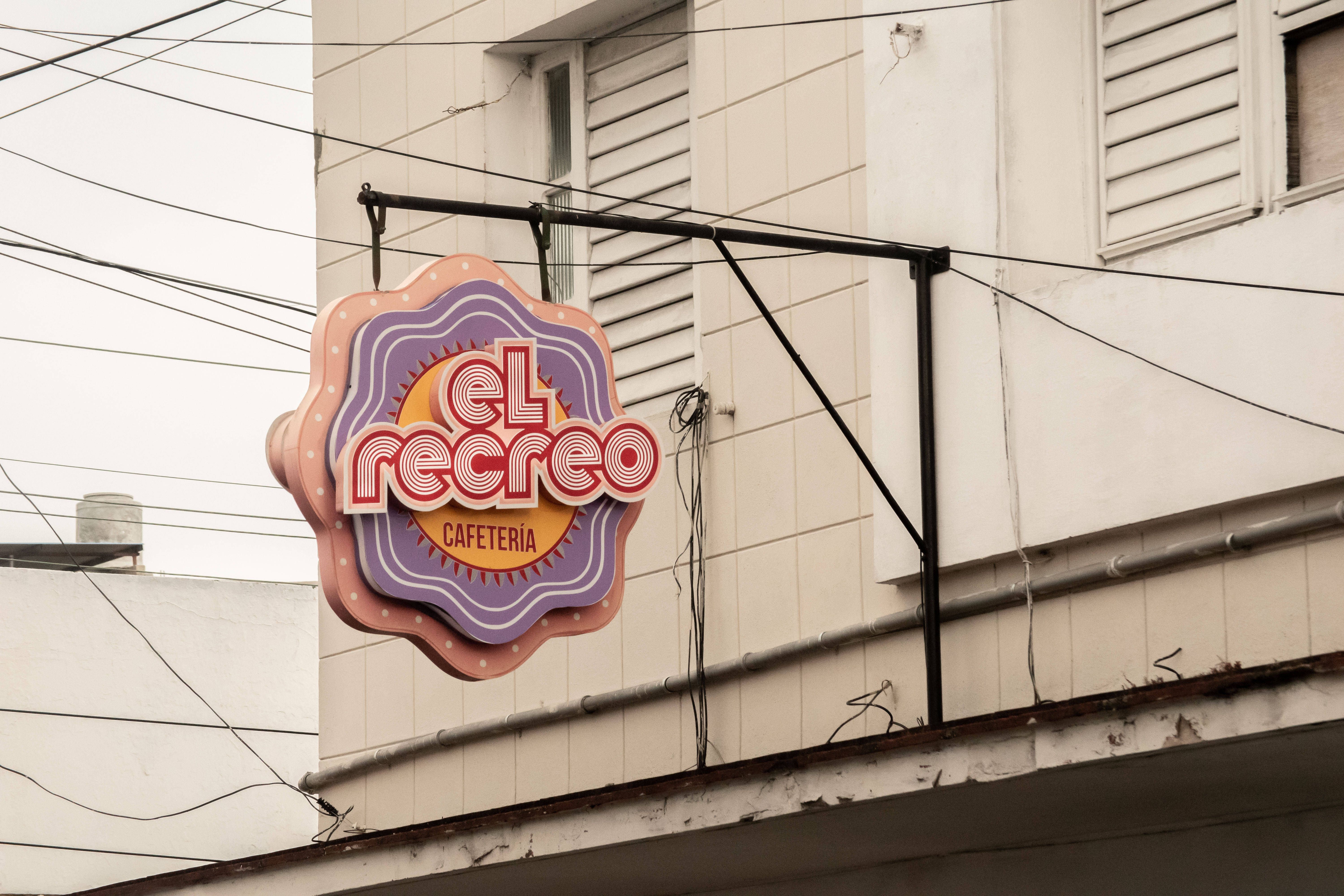 Cuba 桌布 壁紙 — 一個寫有「el recreo」的復古風格咖啡館招牌掛在風化的建築物外牆上，與纏繞的架空電線交織在一起。