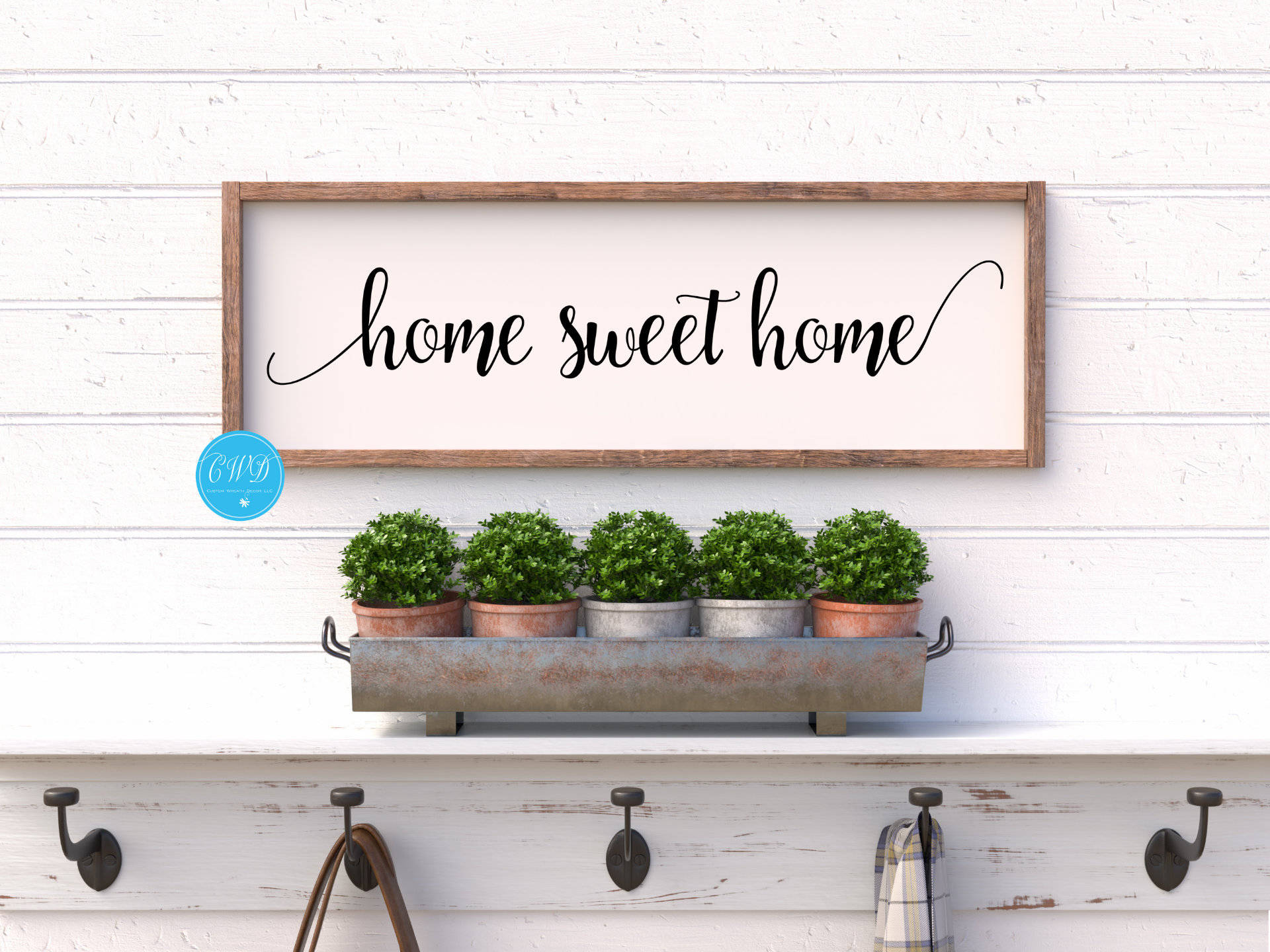 甜蜜的家 桌布 壁紙 — 一個寫著 home sweet home 的鄉村風格木牌掛在白色搭接牆上的一個金屬托盤上方，托盤裡有五盆黃楊。