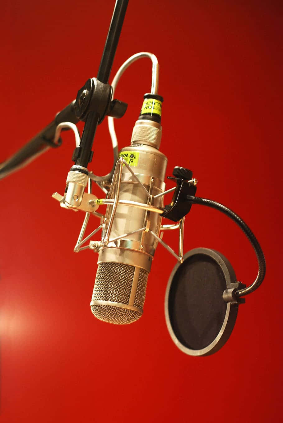 recording 桌布 壁紙 — 一個專業錄音室麥克風連防噴罩掛在鮮紅色的牆上。