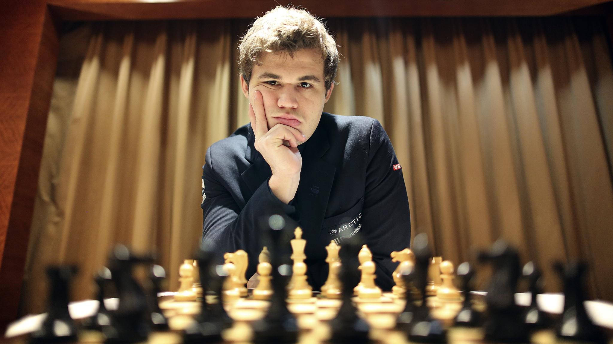 Magnus 桌布 壁紙 — 一個專注的年輕棋手托著下巴，在棋盤上沉思下一步棋。