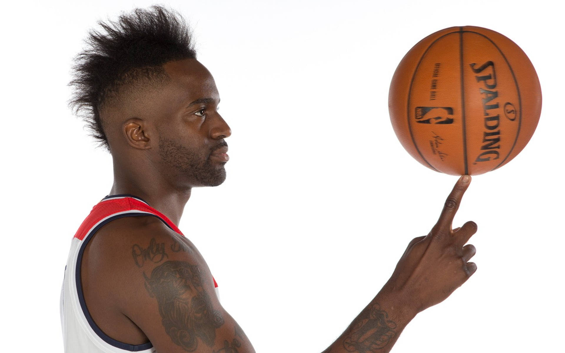 Wizards 桌布 壁紙 — 一個專注的籃球運動員在純白背景前用指尖平衡Spalding籃球。