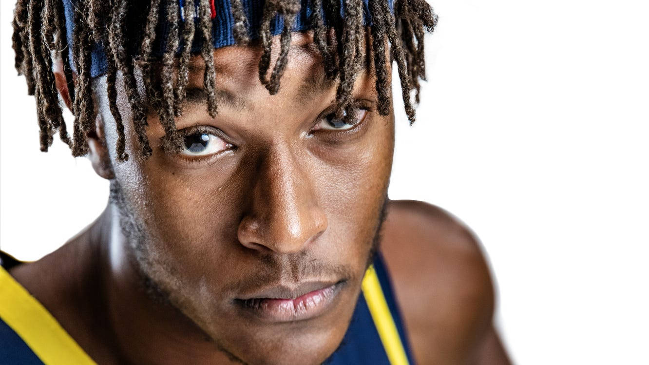 myles turner 桌布 壁紙 — 一個專注的籃球運動員的近距離肖像，他有辮子頭和頭帶，正凝視著相機。