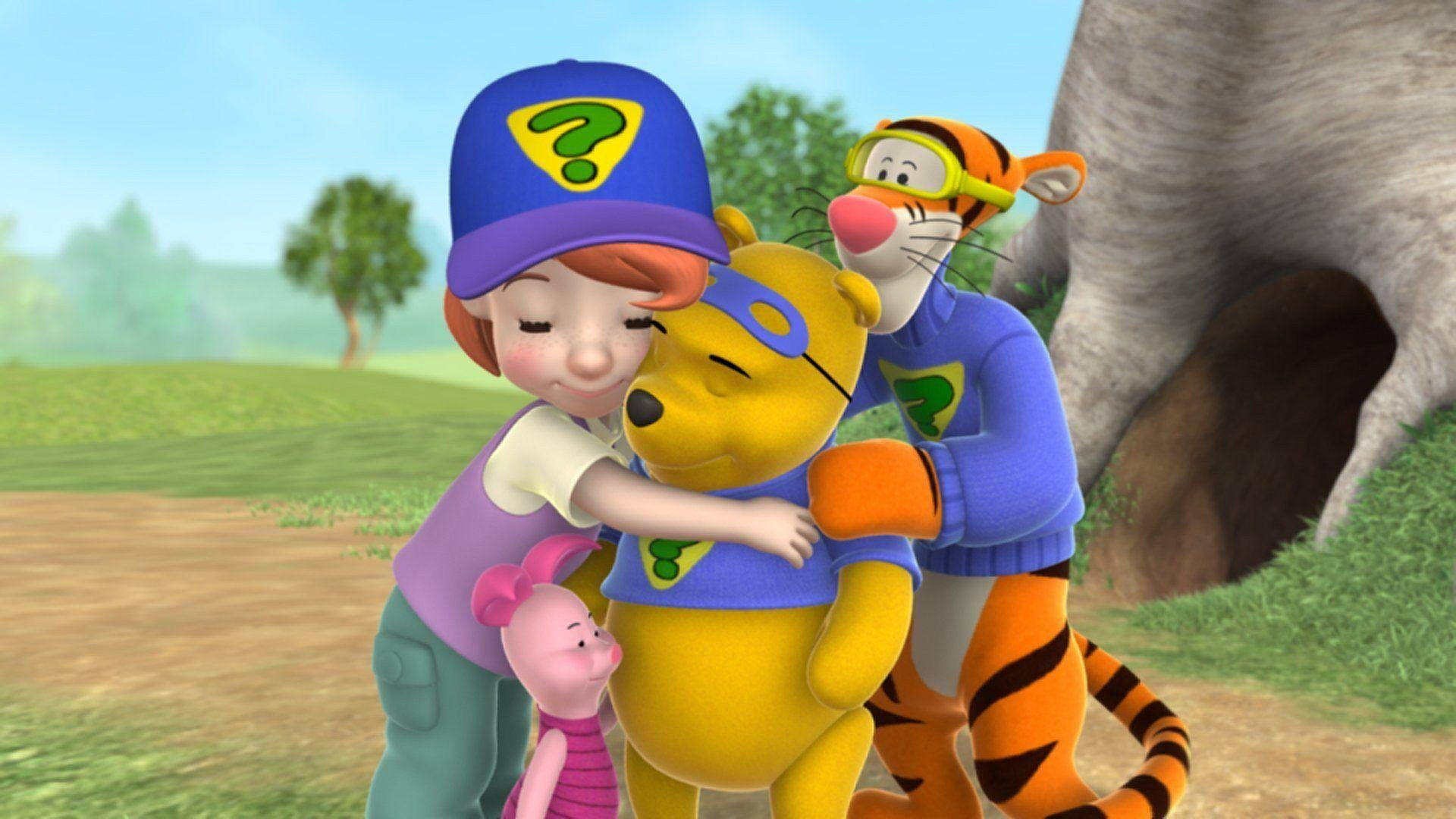 Tigger 桌布 壁紙 — 一個小女孩和跳跳虎在陽光普照的草地上擁抱小熊維尼，附近有樹和洞穴。