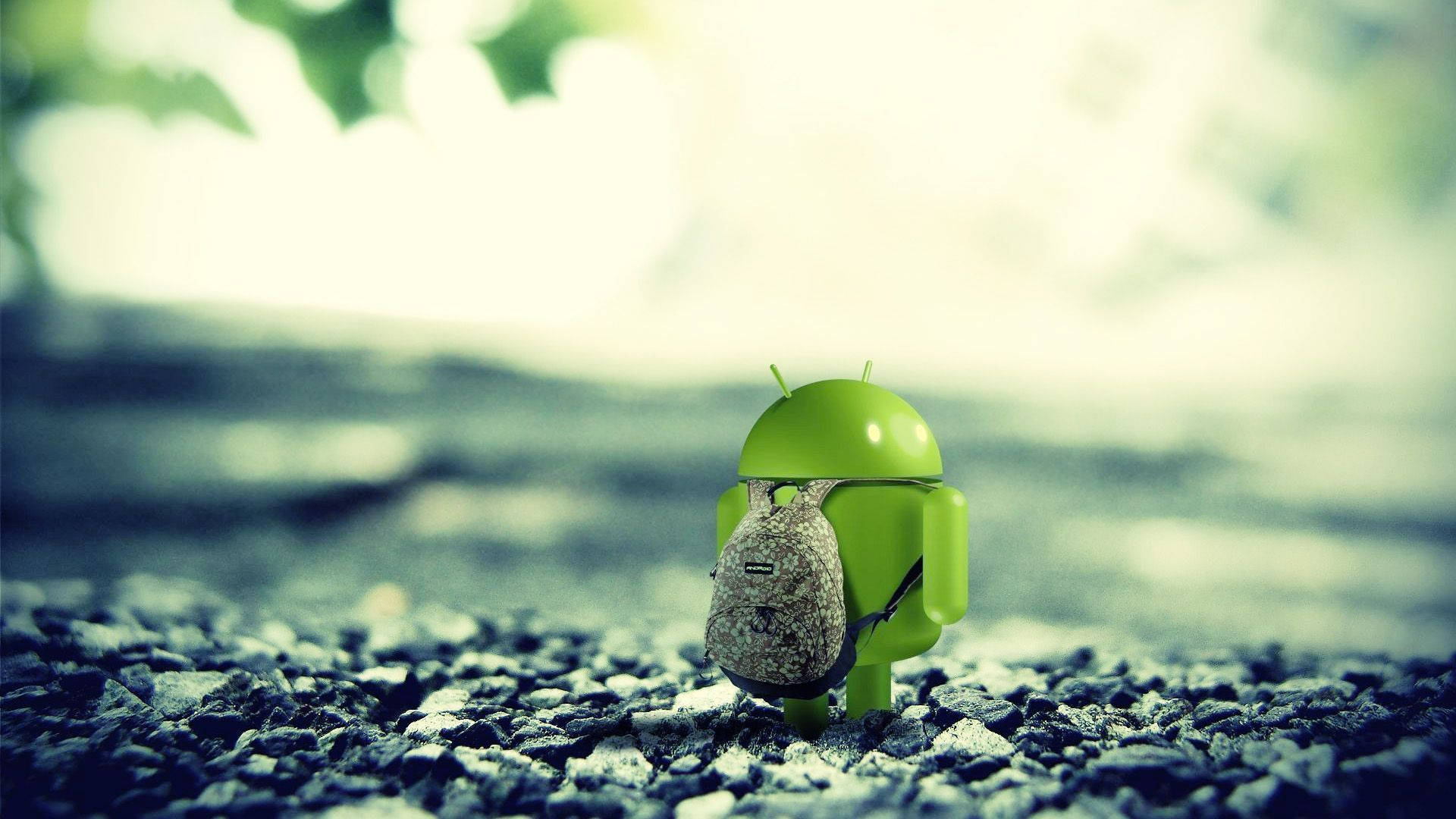 筆電 桌布 壁紙 — 一個小小的綠色Android公仔背著背包，獨自站在碎石路上，柔和自然光下。