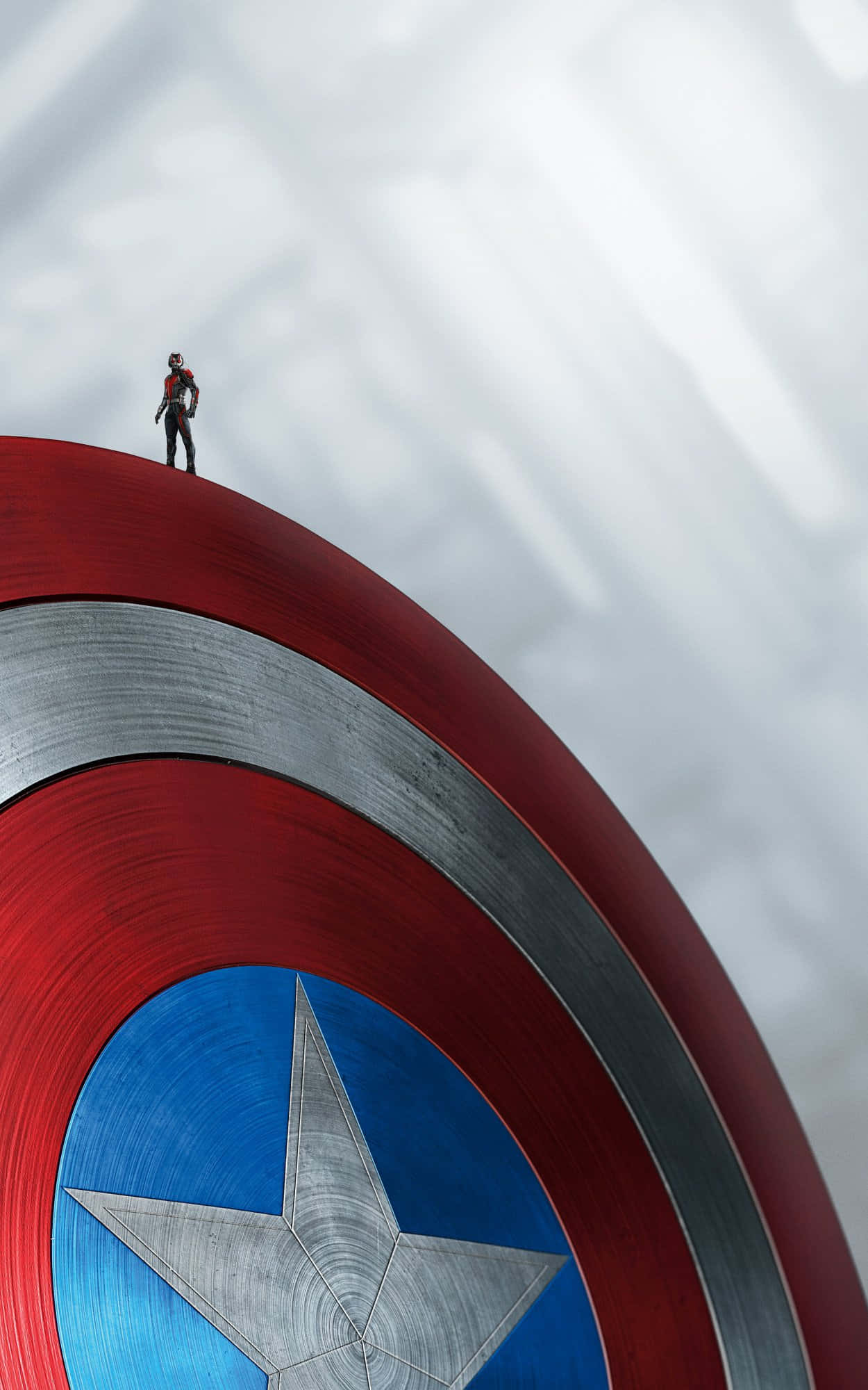 Android Captain America 桌布 壁紙 — 一個小小的超級英雄站在巨大的美國隊長盾牌上，背景是陰天。