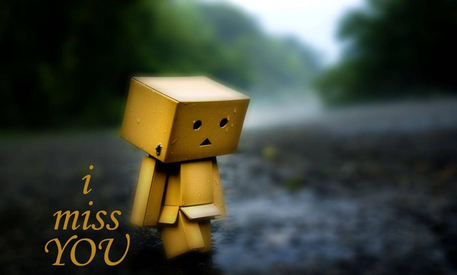 Sad Quotes 桌布 壁紙 — 一個小小的黃色紙箱角色獨自站在雨中，表面有水珠，旁邊有文字 i miss YOU。