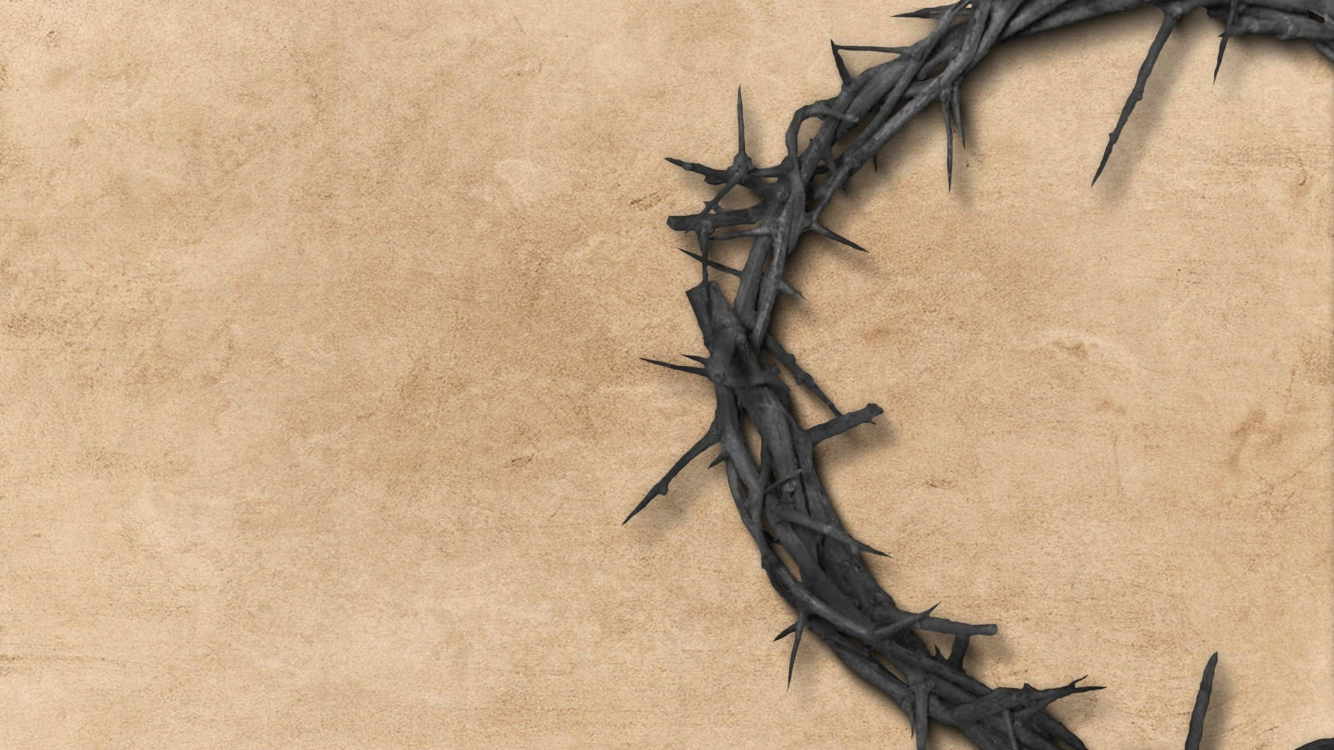 Christ 桌布 壁紙 — 一個尖銳的黑色荊棘冠冕斜放在有紋理的米色羊皮紙背景上。