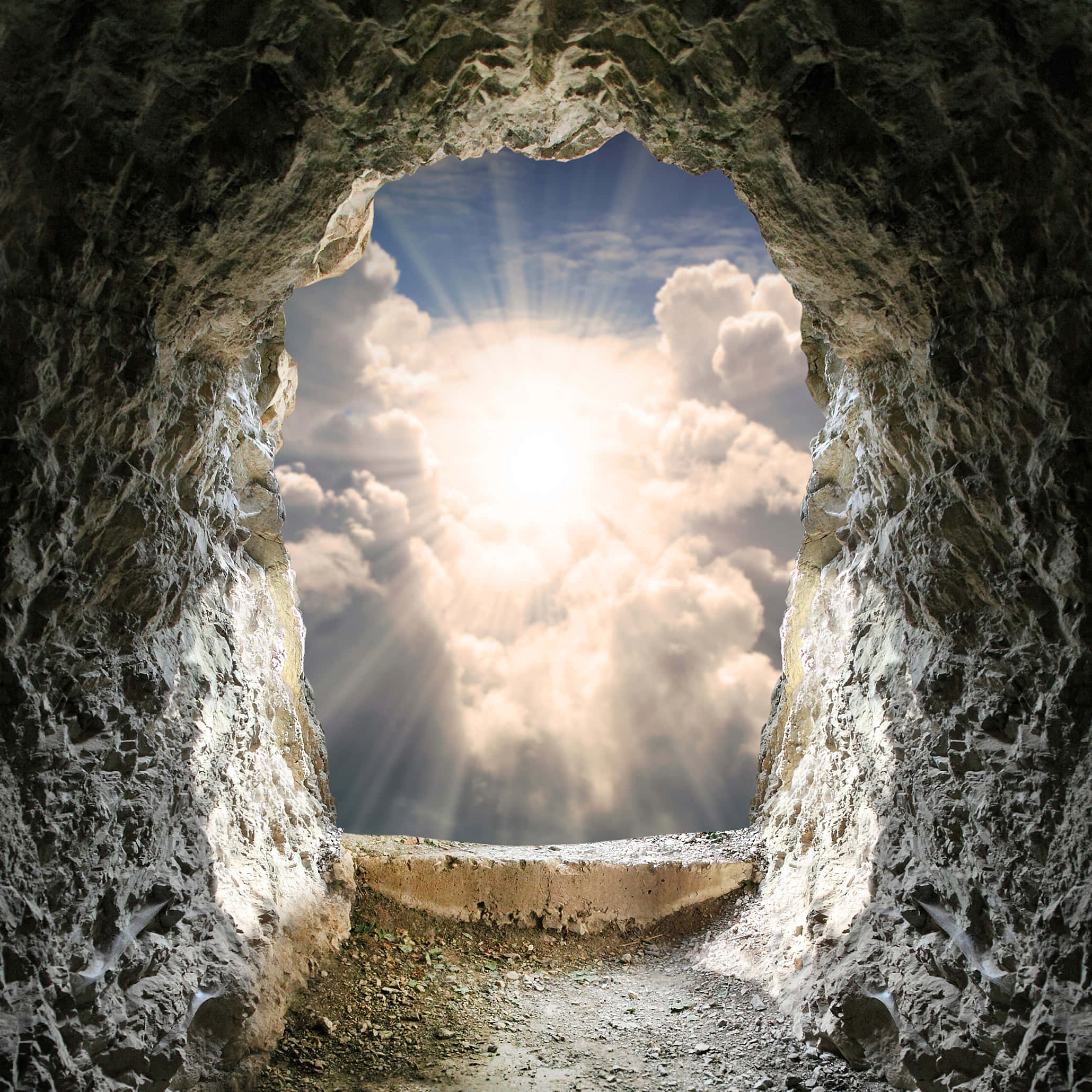 Resurrection 桌布 壁紙 — 一個岩石洞穴入口框住了一道穿過蓬鬆雲層、照耀在石徑上的燦爛陽光。