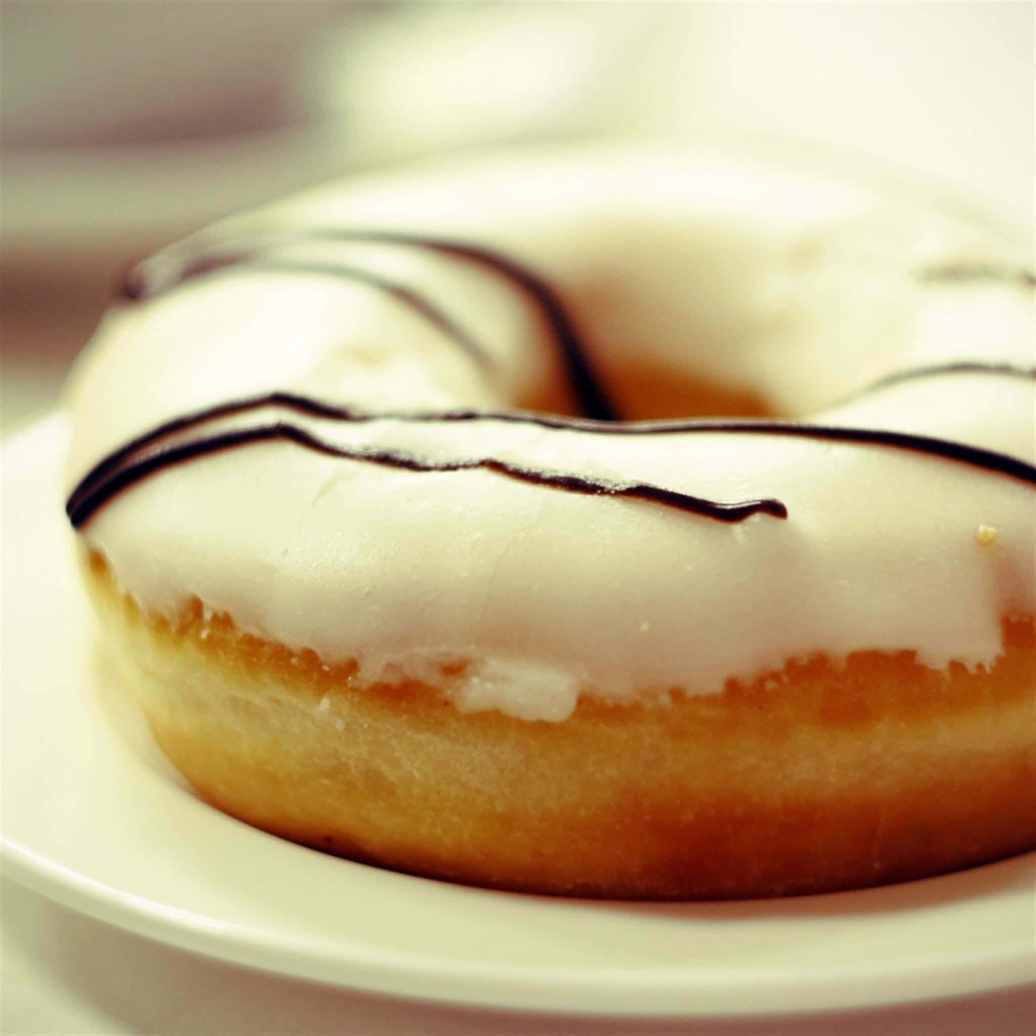 Donut 桌布 壁紙 — 一個巧克力醬釉面甜甜圈的近照，放在白色盤子上。