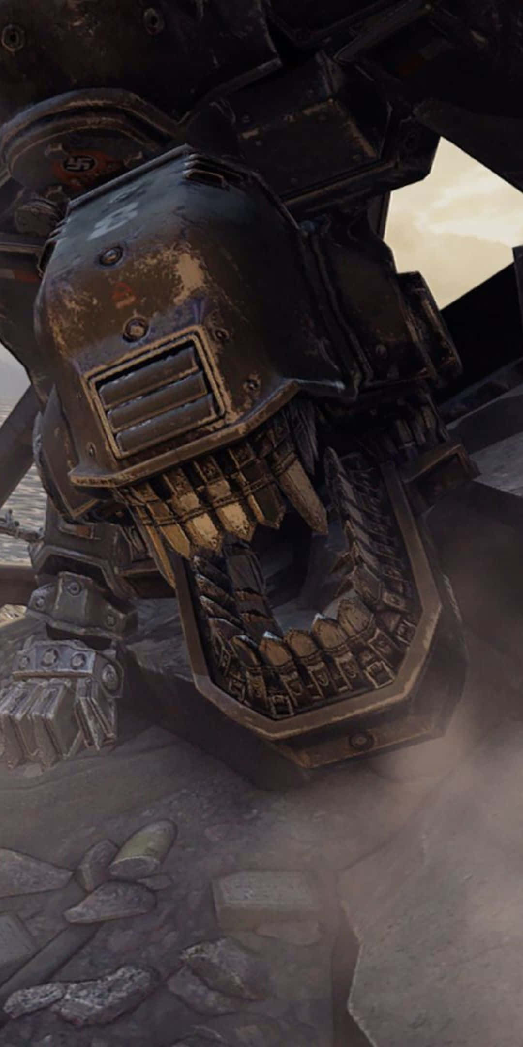 Pixel 3 Wolfenstein Ii 桌布 壁紙 — 一個巨大生鏽的機械頭骨，帶有鋸齒狀牙齒，聳立在荒涼戰場上破碎的石頭上。