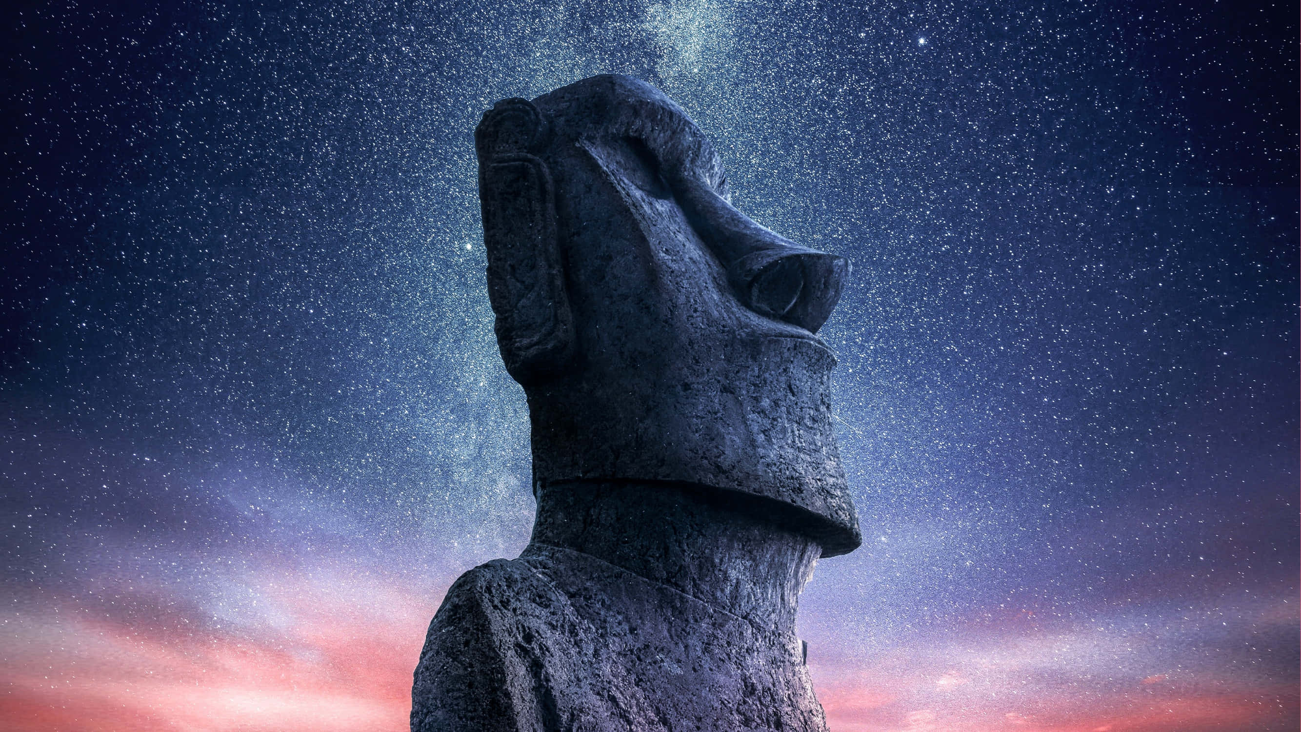 statue 桌布 壁紙 — 一個巨大的石頭摩艾雕像仰望星空，天空帶有粉紅色和紫色的色調。