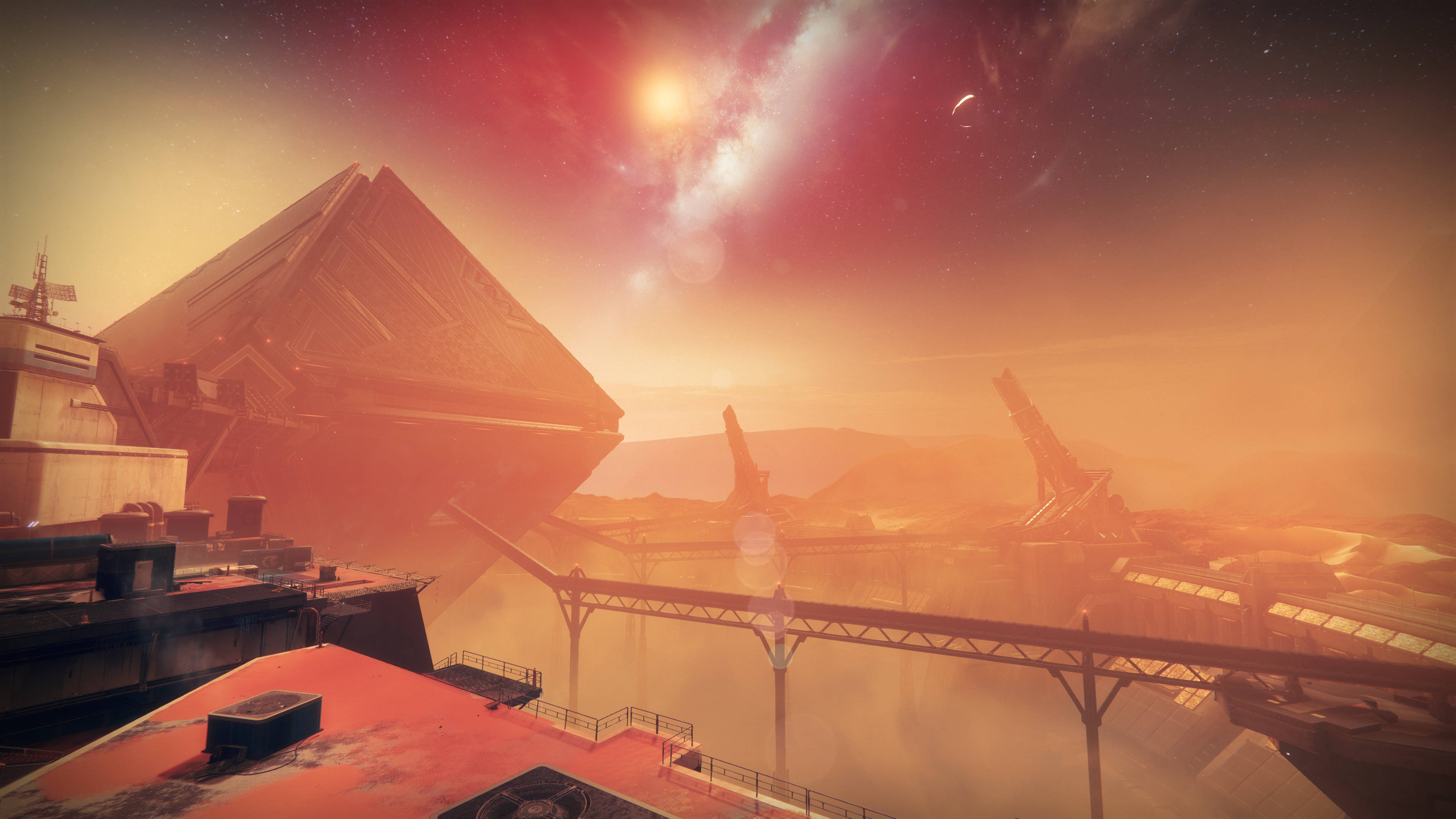 Destiny 2 桌布 壁紙 — 一個巨大的金字塔狀結構主宰著塵土飛揚的外星景觀，天空呈現鮮豔的紅色和橙色，有發光的太陽和遙遠的月亮。