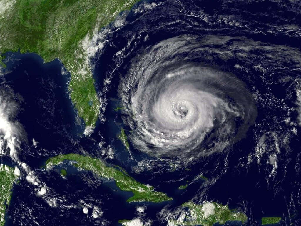 Hurricane 桌布 壁紙 — 一個巨大的颶風在大西洋上空旋轉，帶有清晰的風眼，正接近加勒比海島嶼和美國東南部。