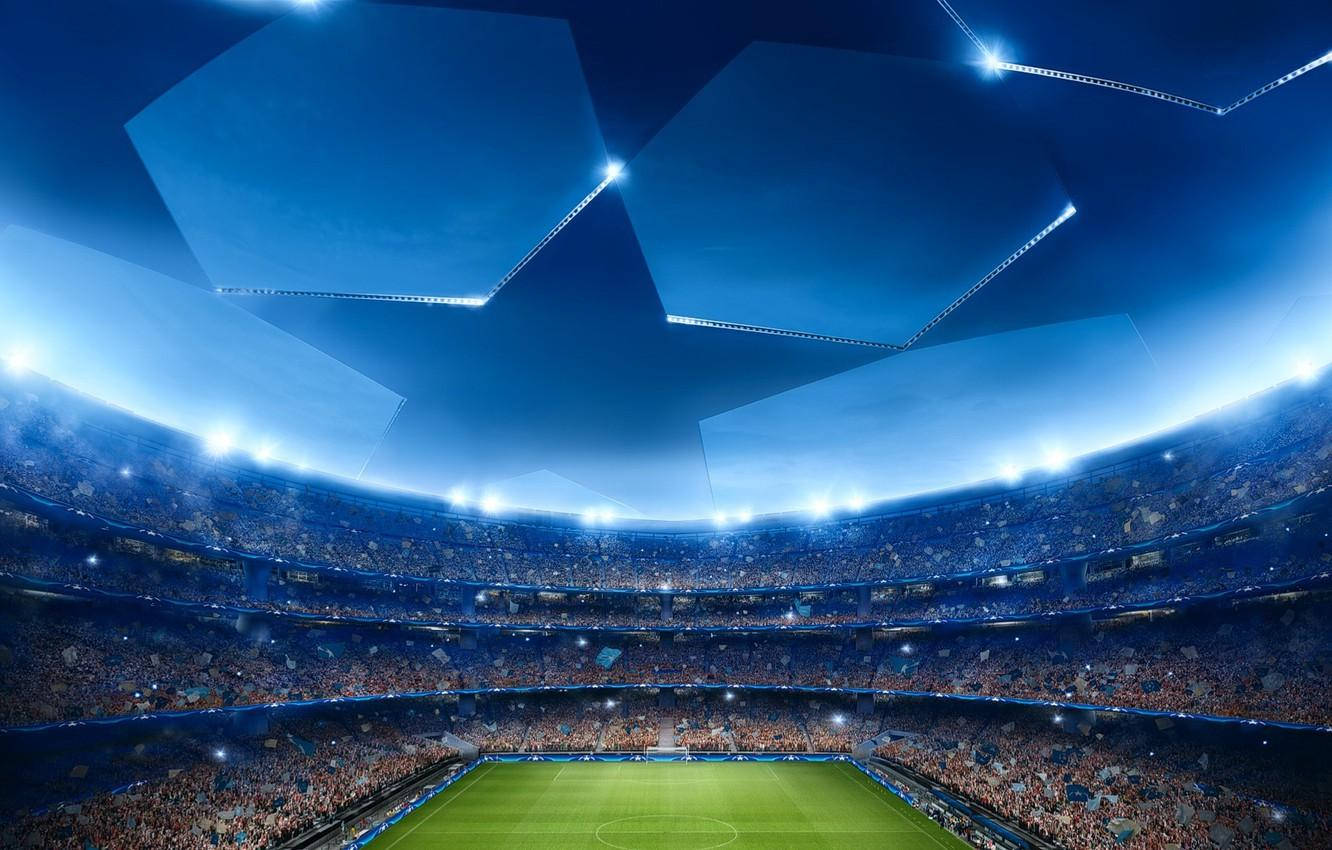 Uefa 桌布 壁紙 — 一個巨大的體育場，充滿了在明亮藍色燈光下歡呼的球迷，照亮了綠色球場。