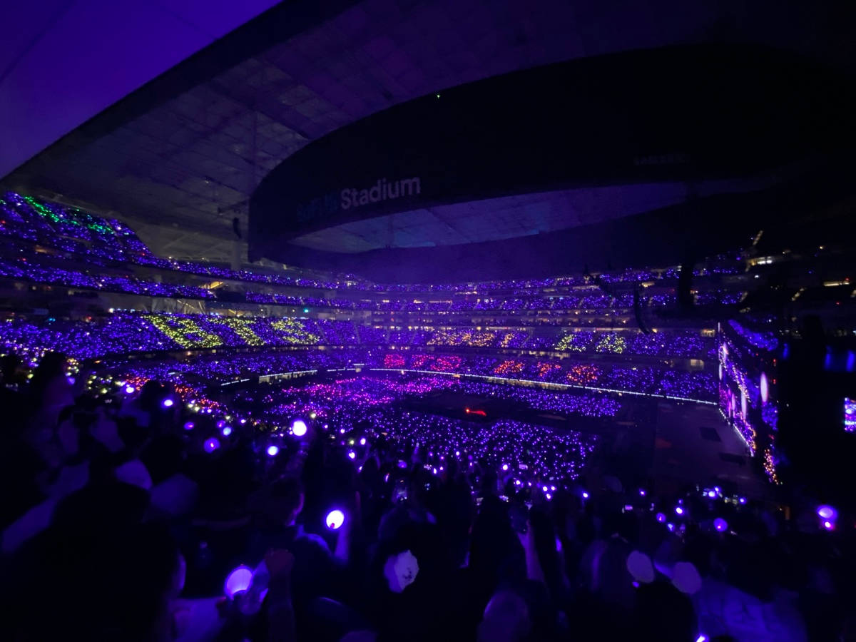 在體育場內手持發光螢光棒的演唱會人群。 — BTS ARMY GIF 壁紙
