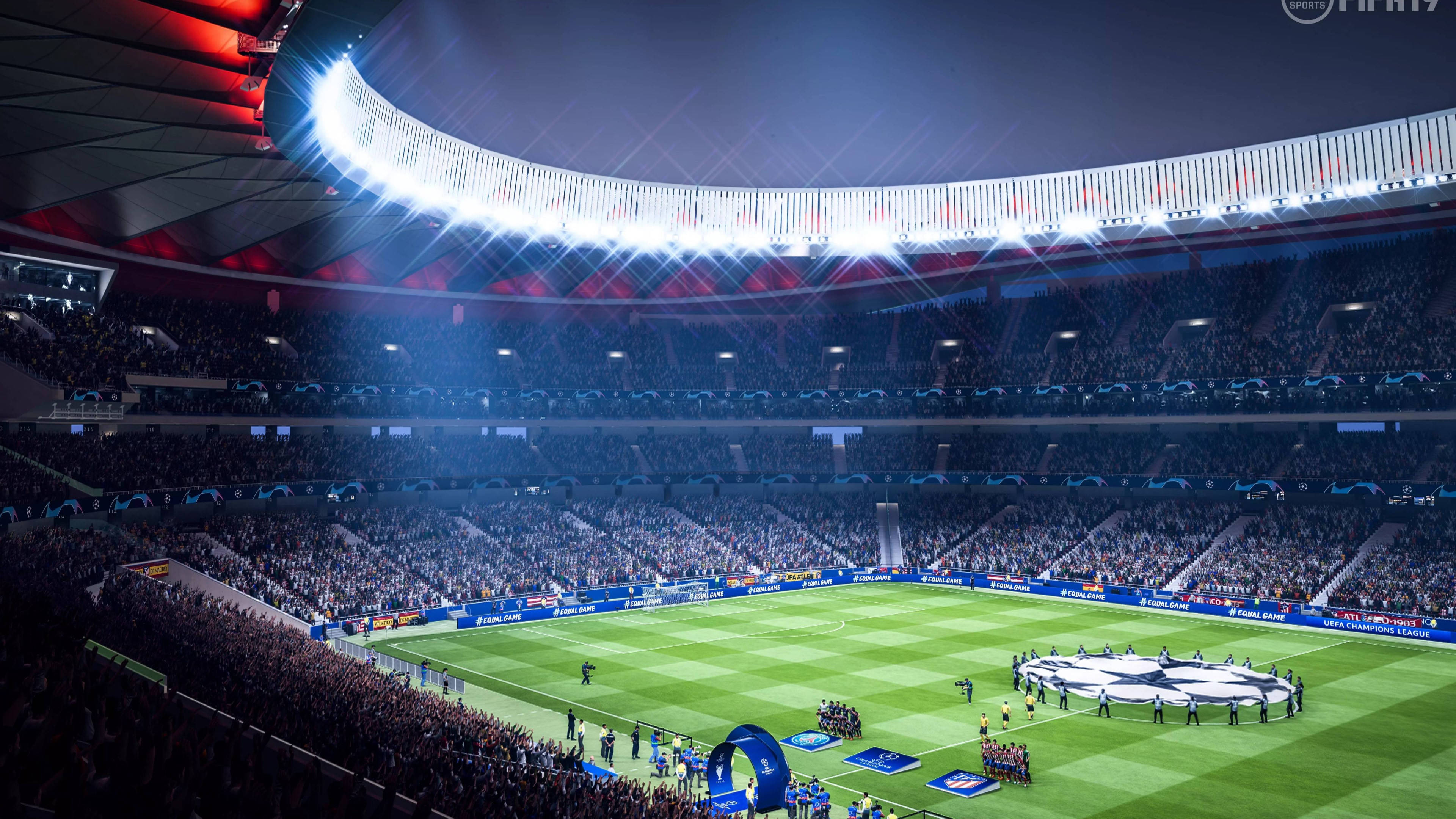 Champions League 桌布 壁紙 — 一個巨大的體育場在夜晚被明亮的燈光照亮，擠滿了人群觀看場上的足球比賽。