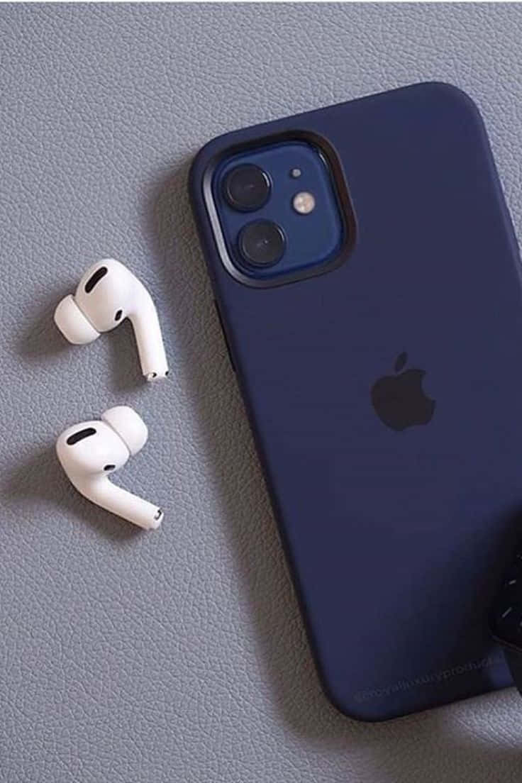 iPhone 12 桌布 壁紙 — 一個帶有Apple標誌的深藍色iPhone保護殼和白色AirPods放在有紋理的灰色表面上。