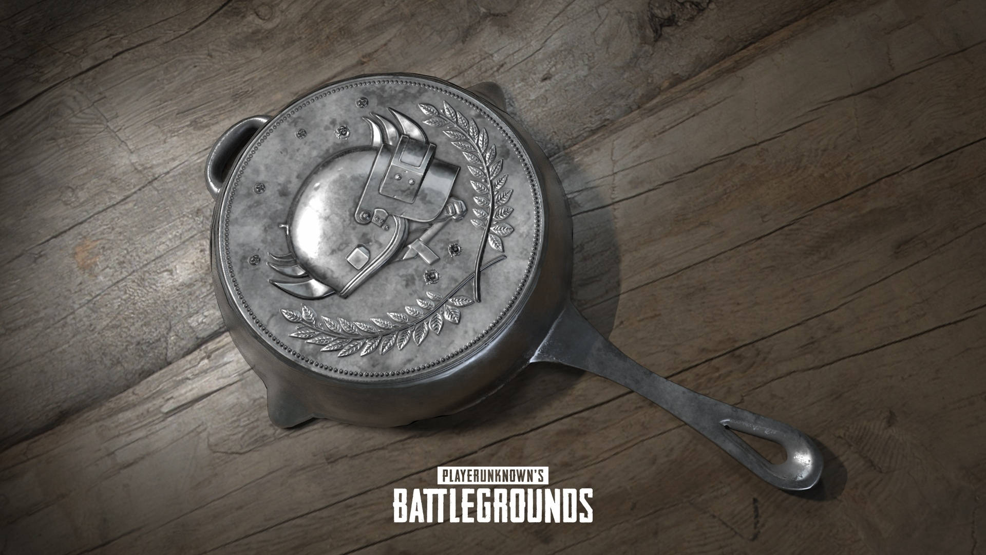 帶有PUBG標誌的金屬煎鍋在木質表面上