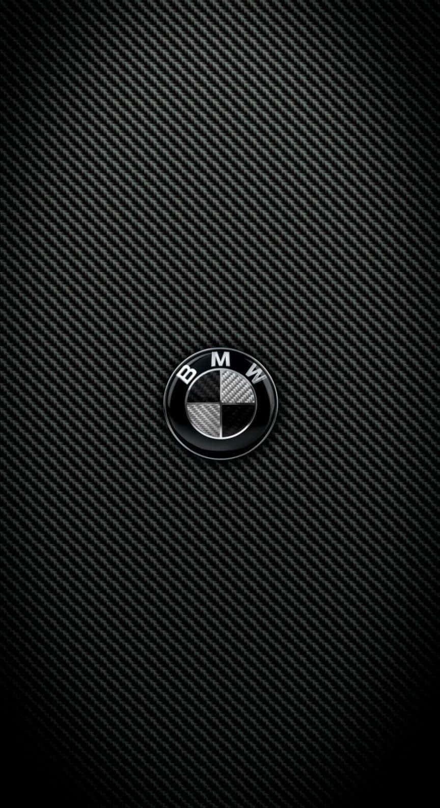 Carbon Fiber iPhone 桌布 壁紙 — 一個帶有光澤的BMW標誌，居中放置在帶有紋理的黑色碳纖維背景上。