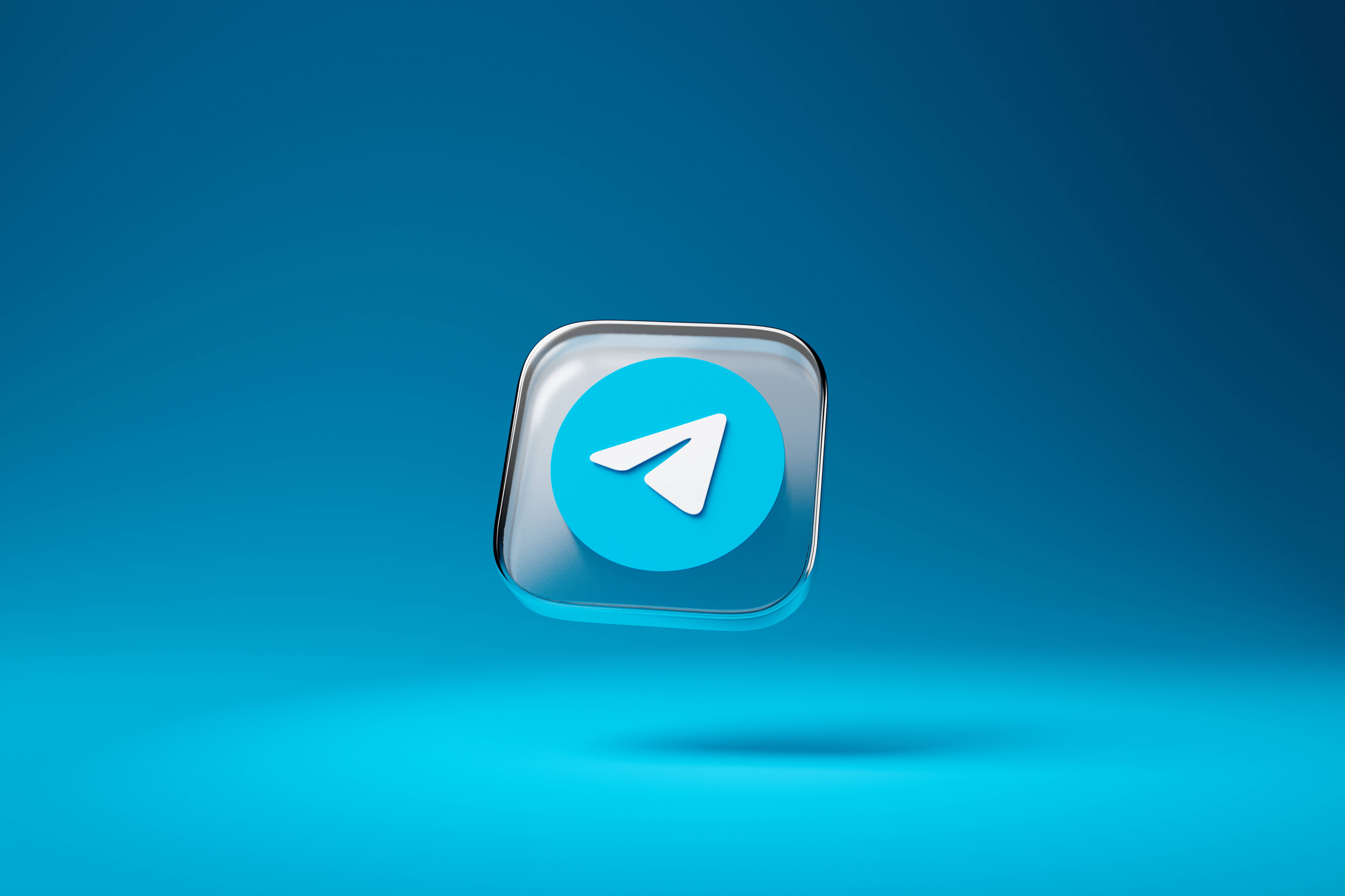 Telegram 桌布 壁紙 — 一個帶有光澤的Telegram應用程式圖示漂浮在帶有柔和陰影的漸變藍色背景上。