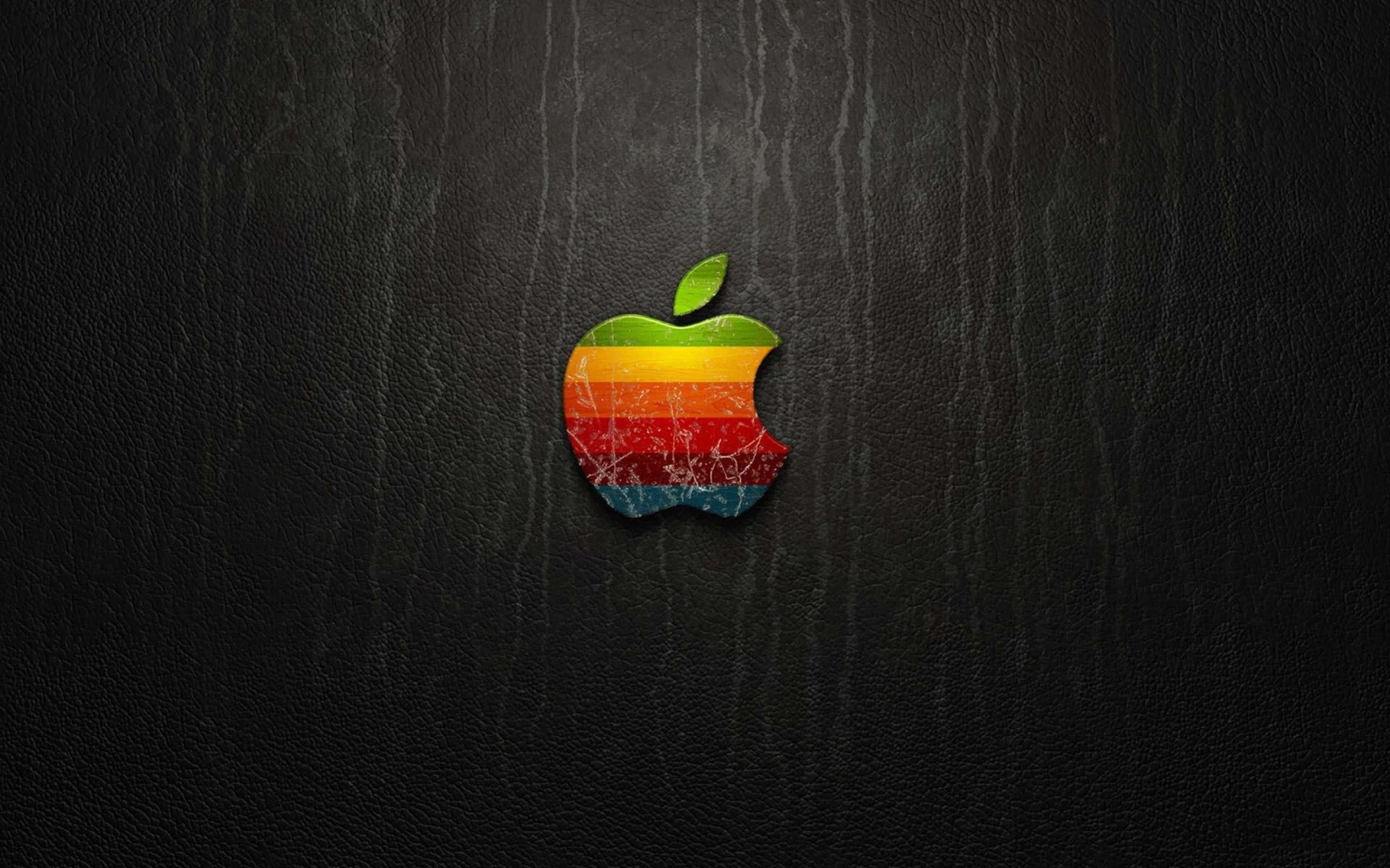 彩色動圖 桌布 壁紙 — 一個帶有咬痕的復古彩虹Apple標誌居中放置在深色紋理皮革背景上。