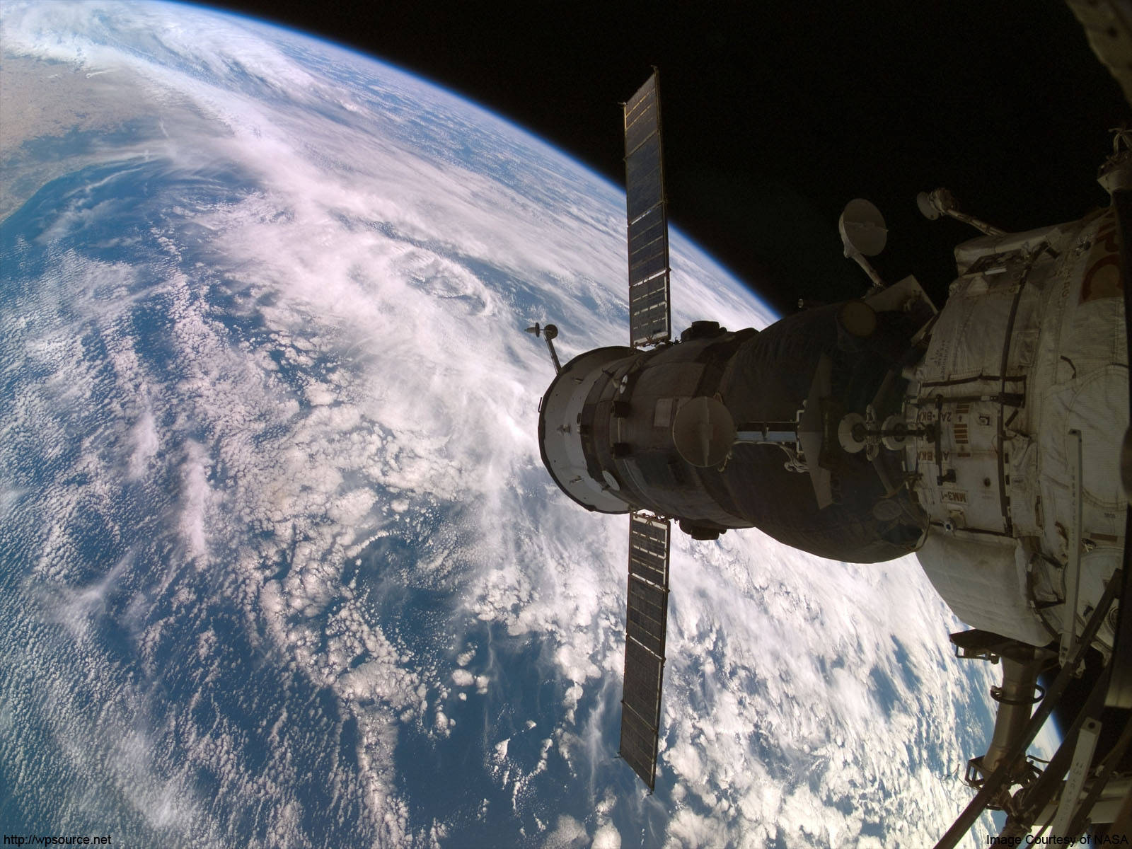 nasa 美學 桌布 壁紙 — 一個帶有太陽能板的太空站，在軌道上看到的彎曲藍白地球背景下延伸。