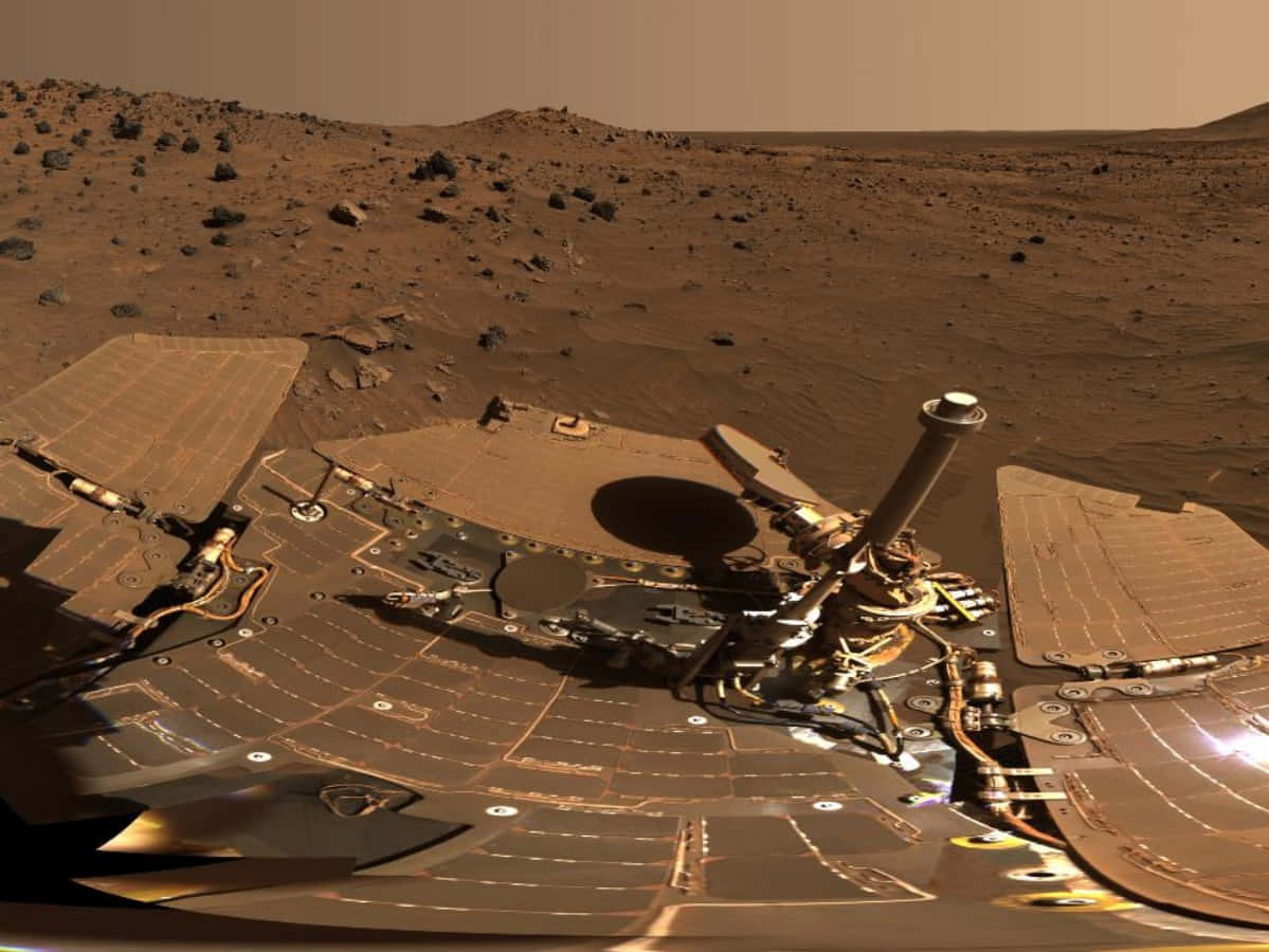 NASA 動態圖片 桌布 壁紙 — 一個帶有太陽能板的機械探測車在朦朧的天空下，停靠在火星生鏽的紅色表面上。