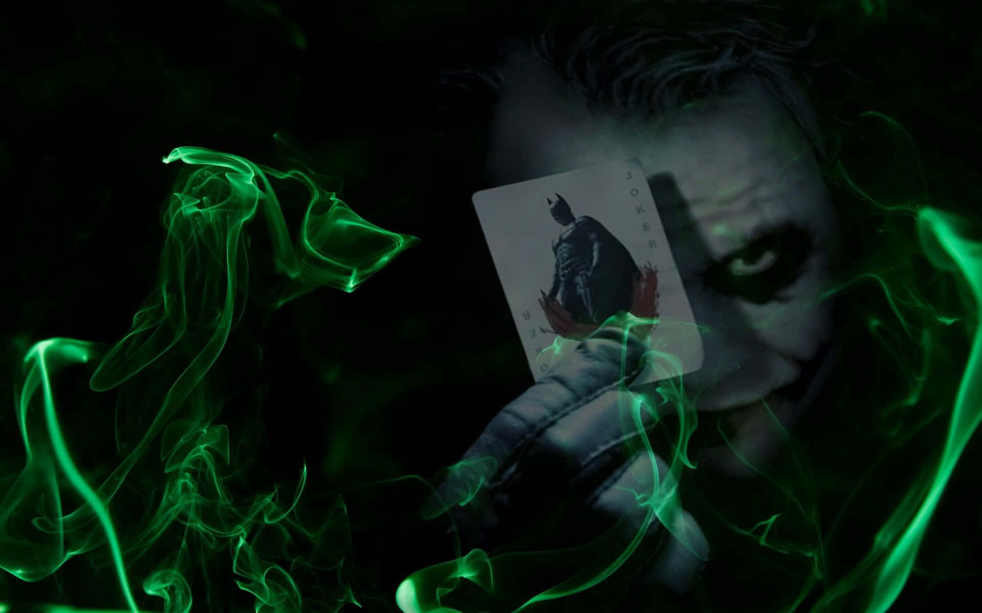 Evil Joker 桌布 壁紙 — 一個帶有威脅性的小丑手持蝙蝠俠小丑卡，詭異的綠色煙霧在黑暗中圍繞著他蒼白的臉龐旋轉。
