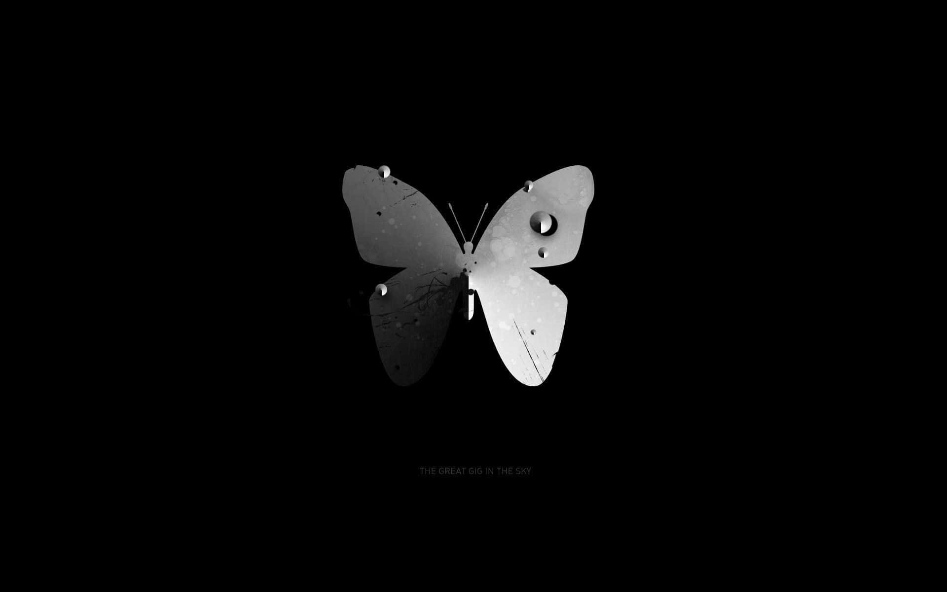 Dark Butterfly 桌布 壁紙 — 一個帶有孔洞和刮痕的極簡金屬蝴蝶剪影，在純黑背景上浮現。