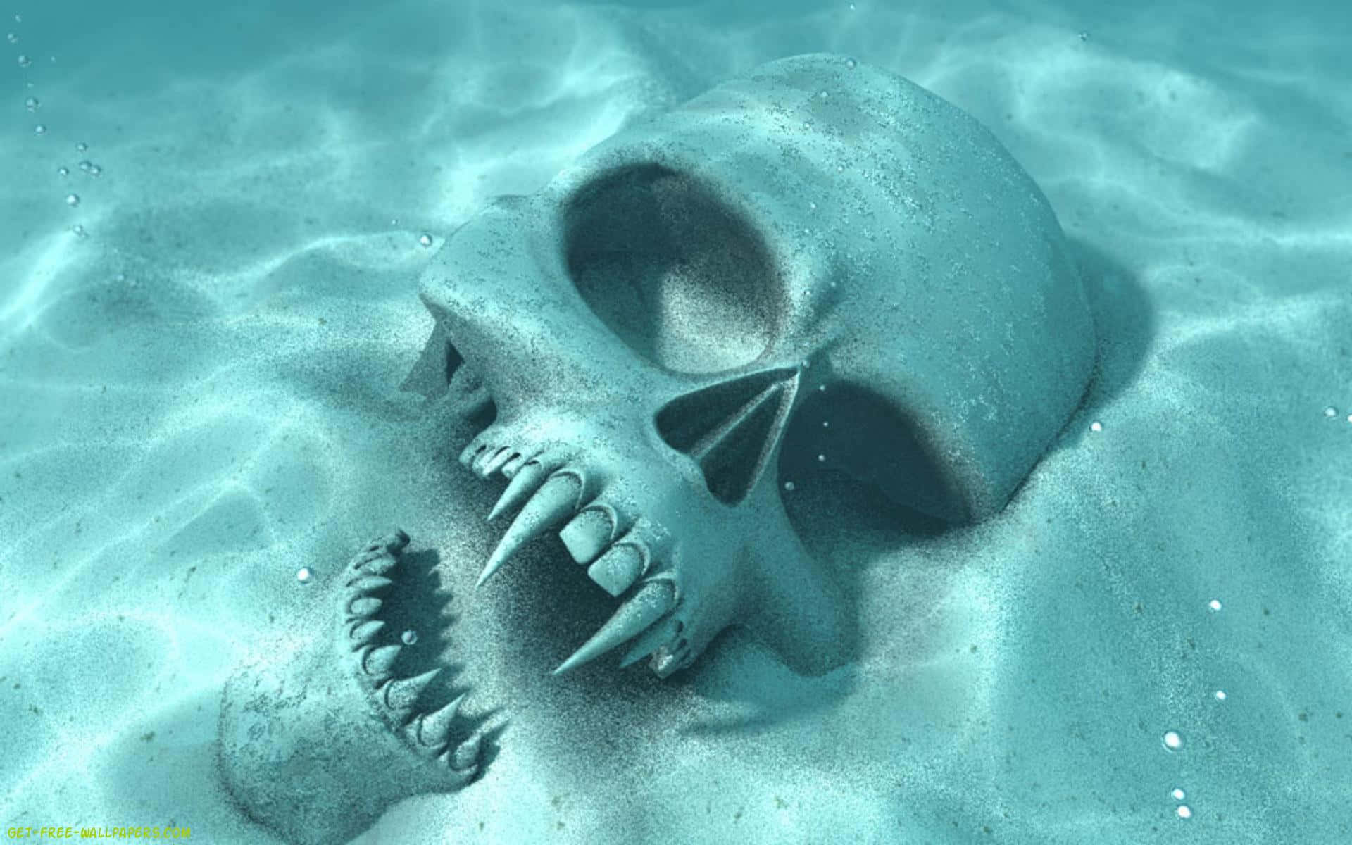 Creepy Ocean 桌布 壁紙 — 一個帶有尖銳牙齒的化石頭骨埋在綠松石色的沙中，位於水下，光線透過水照射進來。