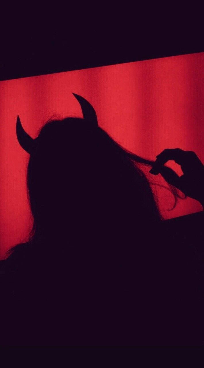 Sad Demon Girl 桌布 壁紙 — 一個帶有惡魔角的人影，襯著鮮紅色窗簾背景。