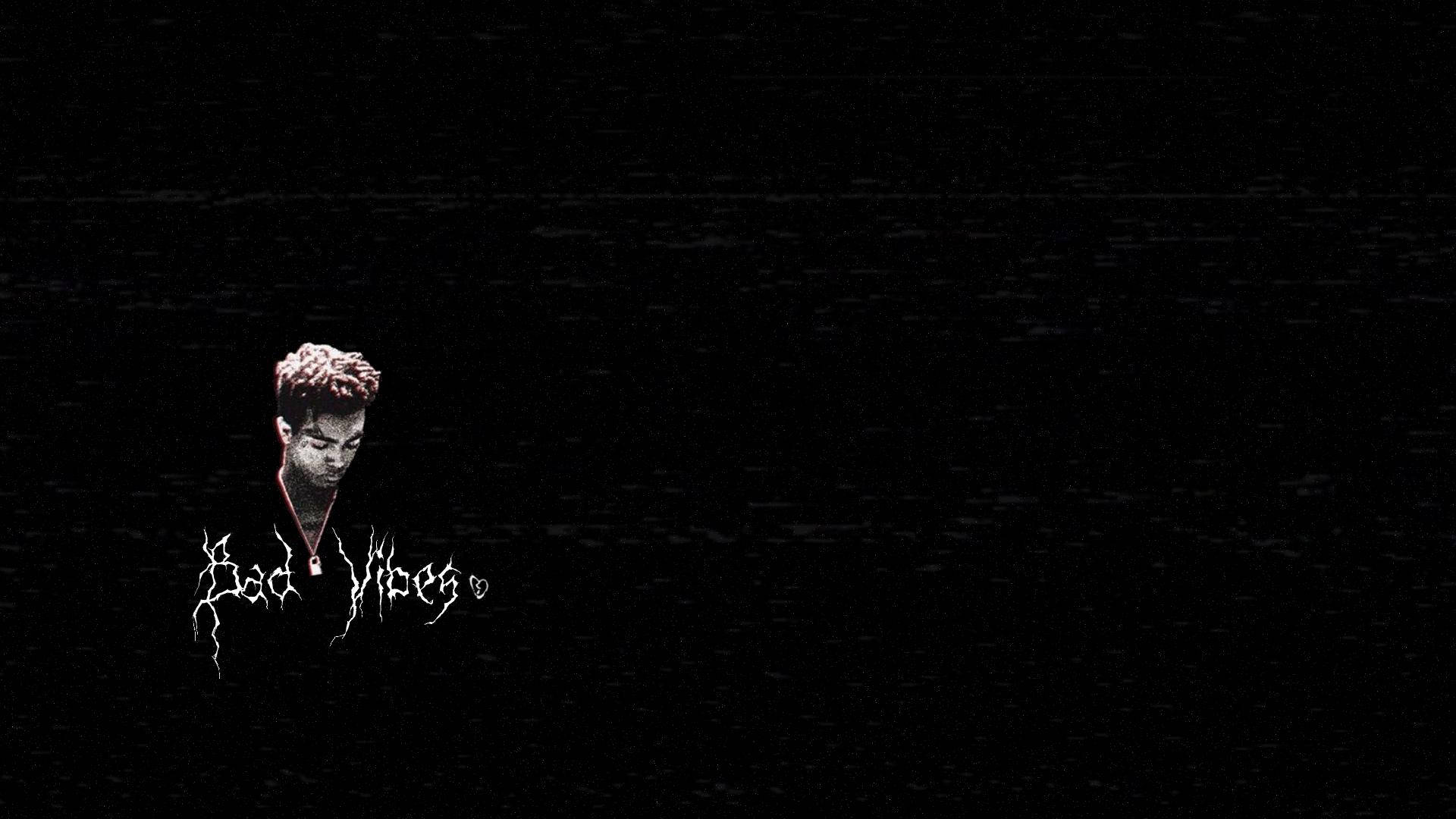 xxxtentacion 動畫 桌布 壁紙 — 一個帶有故障效果的人物肖像，紅髮戴項鍊，背景為黑色靜態，帶有白色「Bad Vibes」文字。